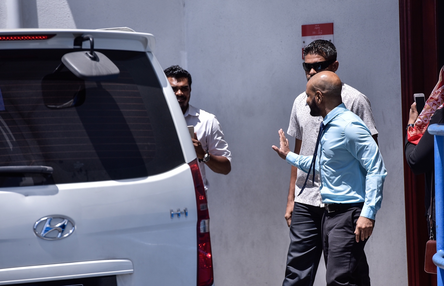 މާލެ: ޖުލައި 23، 2017- ރައްޔިތުންގެ މަޖިލީހުގެ ދިއްގަރު ދާއިރާގެ މެމްބަރު ފާރިސް މައުމޫން ޕީޕީއެމްގެ ދިދަ އާއި ލޯގޯ ގަވާއިދާ ޚިލާފަށް ބޭނުންކުރި ކަމަށް ބުނެ އޭނާގެ މައްޗަށް ކުރާ ދައުވާއާ ގުޅިގެން މިއަދު ކްރިމިނަލް ކޯޓުގައި ބޭއްވި އިބްތިދާއީ އަޑުއެހުމަށް ފަހު އޭނާ ދޫނިދު އަށް ގެންދިއުމަށްޓަކައި ފުލުހުންގެ ވެހިކަލަށް އަރުވަނީ.---މިހާރު ފޮޓޯ: ހުސެއިން ވަހީދު