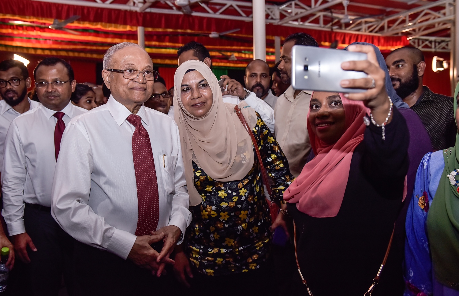 ޖުލައި 23، 2017- އިދިކޮޅު ފަރާތްތަކުން މ. ކުނޫޒްގައި ބޭއްވި ޖަލްސާގައި ކުރީގެ ރައީސް މައުމޫނާއެކު ބަޔަކު ސެލްފީއެއް ނަގަނީ.---މިހާރު ފޮޓޯ: ހުސެއިން ވަހީދު