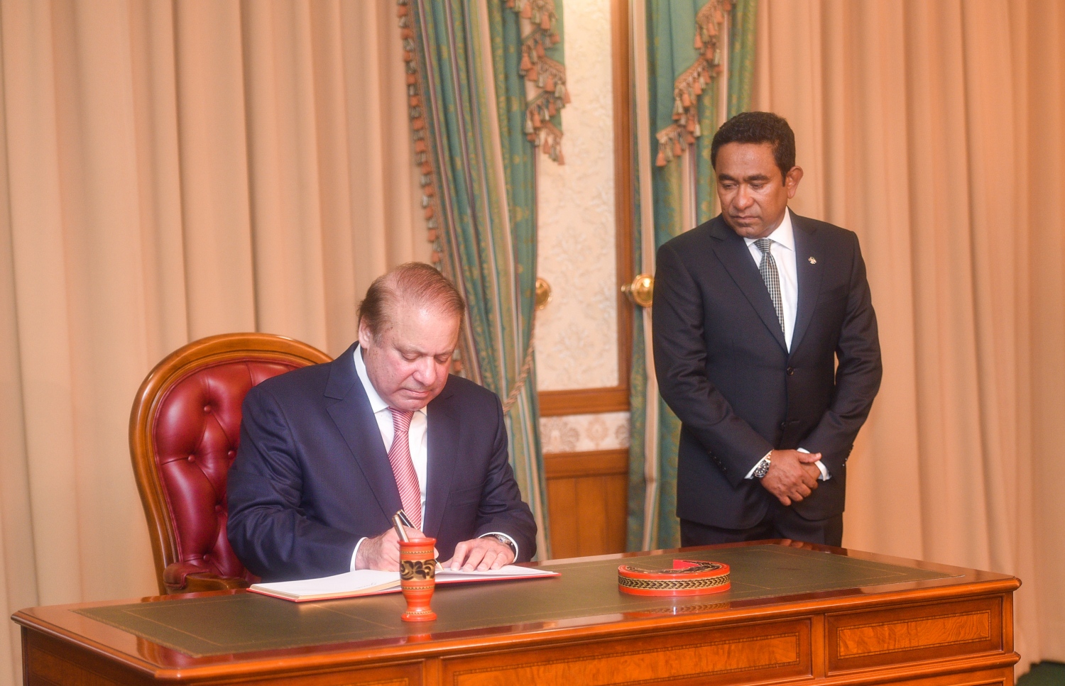 މާލެ: ޖުލައި 25، 2017- މިނިވަން ދުވަހުގެ ރަސްމިއްޔާތު ޝަރަފުވެރި ކޮށްދެއްވުމަށް ވަޑައިގެންނެވި ޕާކިސްތާނުގެ ބޮޑުވަޒީރު ނަވާޒް ޝަރީފް ރައީސް އޮފީހުގައި މިއަދު މެހުމާނުންގެ ފޮތުގައި ސޮއިކުރައްވަނީ -- ފޮޓޯ: ރައީސް އޮފީސް