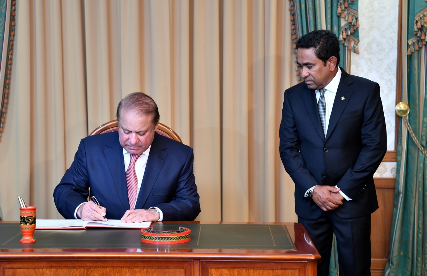 ޕާކިސްތާނުގެ ބޮޑުވަޒީރު ނަވާޒް ޝަރީފް، ރައީސް އޮފީހުގައި މެހުމާނުން ސޮއިކުރައްވާ ފޮތުގައި ލިޔުއްވަނީ.---ފޮޓޯ: ރައީސް އޮފީސް