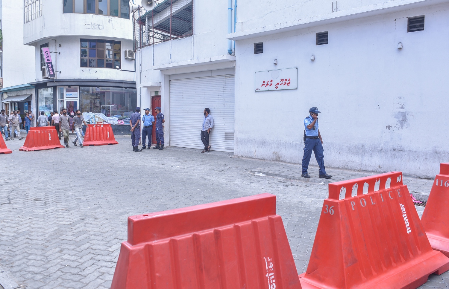 އިދިކޮޅު ފަރާތްތަކުން ޖަލްސާ ބާއްވާ ކުނޫޒު ހިމެނޭ ސަރަހައްދު ބަންދުކޮށް، ފުލުހުން އެ އިމާރާތުގެ ބޭރުގައި ފޯރިމަރަނީ.---މިހާރު ފޮޓޯ: ހުސެއިން ވަހީދު