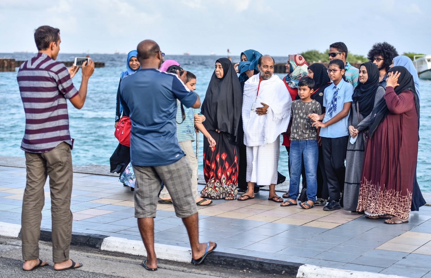 ވެލާނާ އިންޓަނޭޝަނަލް އެއާޕޯޓް: އޮގަސްޓް 7، 2017- ދިވެހި ހައްޖުވެރިންގެ ފުރަތަމަ ގުރޫޕުގެ ބަޔަކު މިއަދު ފުރުމުގެ ކުރިން އާއިލާގެ މީހުންނާއެކު ފޮޓޯ ނަގަނީ: ދިވެހި ހައްޖުވެރިން މިއަދު ފުރަން ފަށާފައިވާއިރު، ހަތަރު ގުރޫޕަކުން މި އަހަރު މީހުން ހައްޖަށް ދާނެ.---މިހާރު ފޮޓޯ: ހުސެއިން ވަހީދު