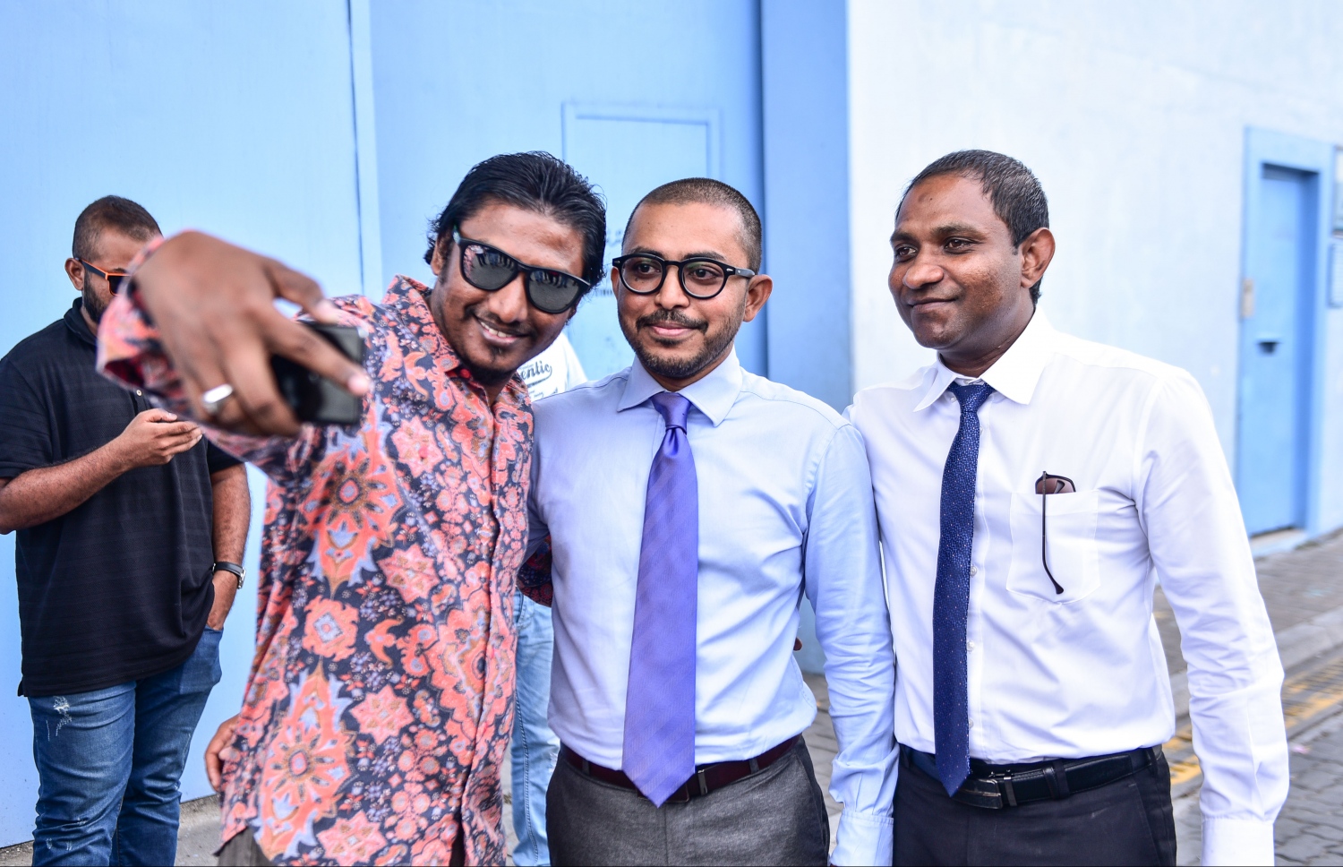 އަމީތާއި ސައުދު މިއަދު މިނިވަންވުމުން، ފުލުހުންގެ ކަސްޓޯޑިއަލް ސެކްޝަންގެ ބޭރުގައި ސްޓެޕިން އައްޔަ އެ ދެ ބޭފުޅުންނާއެކު ސެލްފީއެއް ނަގަނީ.---މިހާރު ފޮޓޯ: ހުސެއިން ވަހީދު