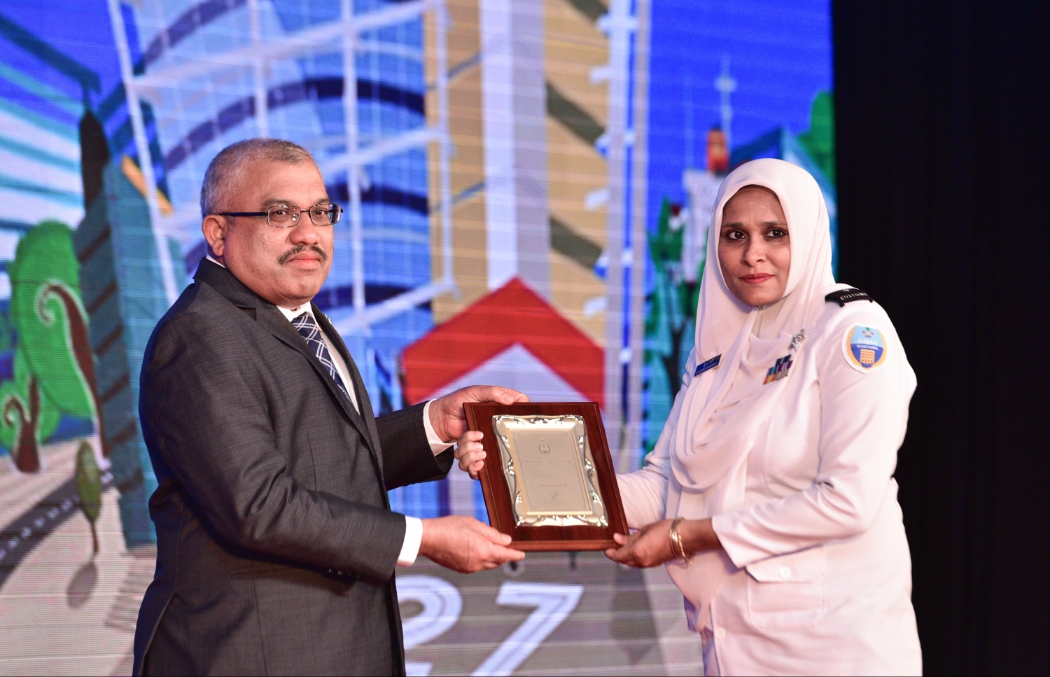 މާލެ: އޮގަސްޓް 20، 2017- ކަސްޓަމްސްގެ 127 ވަނަ އަހަރީ ދުވަހުގެ މުނާސަބަތުގައި ބޭއްވި ޚާއްސަ ޖަލްސާގައި، އެ އިދާރާ އަށް 20 އަހަރަށް ވުރެ ގިނަ ދުވަހު ޚިދުމަތް ކުރި މުވައްޒަފަކާ ނައިބު ރައީސް ޖިހާދު ހަނދާނީ ފިލާ ހަވާލުކޮށްދެއްވަނީ.---މިހާރު ފޮޓޯ: ހުސެއިން ވަހީދު