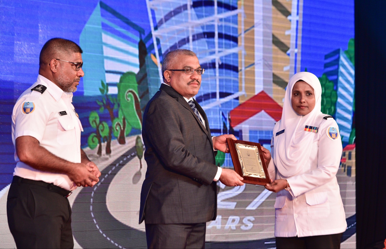 މާލެ: އޮގަސްޓް 20، 2017- ކަސްޓަމްސްގެ 127 ވަނަ އަހަރީ ދުވަހުގެ މުނާސަބަތުގައި ބޭއްވި ޚާއްސަ ޖަލްސާގައި، އެ އިދާރާ އަށް 20 އަހަރަށް ވުރެ ގިނަ ދުވަހު ޚިދުމަތް ކުރި މުވައްޒަފަކާ ނައިބު ރައީސް ޖިހާދު ހަނދާނީ ފިލާ ހަވާލުކޮށްދެއްވަނީ.---މިހާރު ފޮޓޯ: ހުސެއިން ވަހީދު