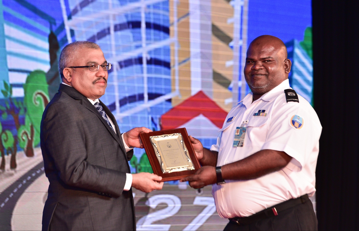 މާލެ: އޮގަސްޓް 20، 2017- ކަސްޓަމްސްގެ 127 ވަނަ އަހަރީ ދުވަހުގެ މުނާސަބަތުގައި ބޭއްވި ޚާއްސަ ޖަލްސާގައި، އެ އިދާރާ އަށް 20 އަހަރަށް ވުރެ ގިނަ ދުވަހު ޚިދުމަތް ކުރި މުވައްޒަފަކާ ނައިބު ރައީސް ޖިހާދު ހަނދާނީ ފިލާ ހަވާލުކޮށްދެއްވަނީ.---މިހާރު ފޮޓޯ: ހުސެއިން ވަހީދު