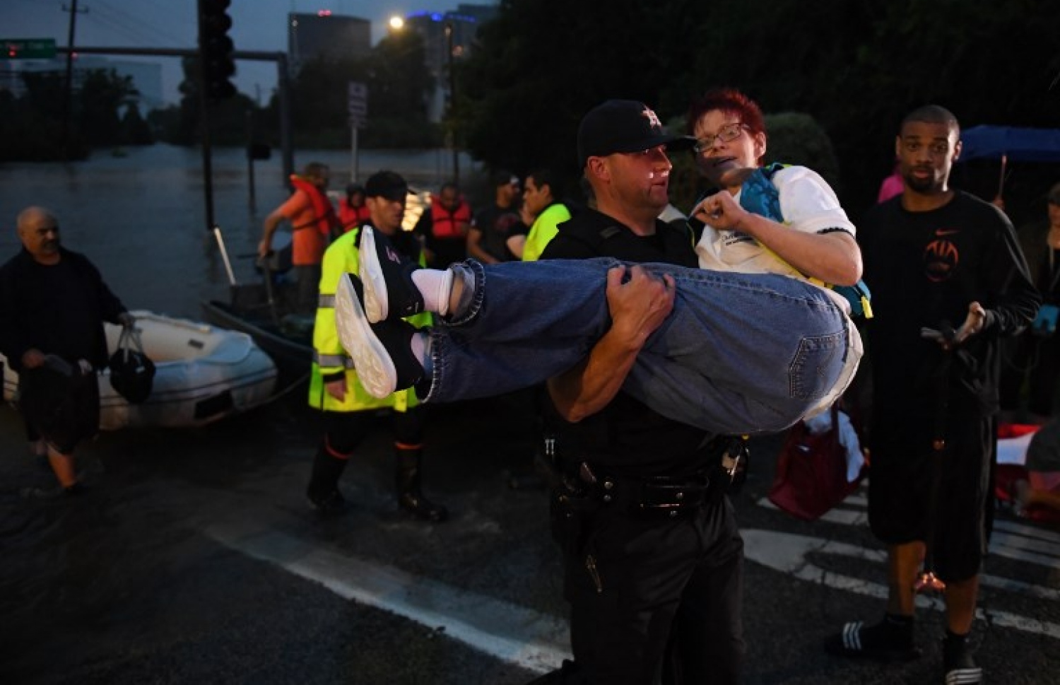 ހިއުސްޓަންގެ ފެންބޮޑުވެފައިވާ ސަރަހައްދެއްގެ ހޮޓަލުން އަންހެނަކު ގެންދަނީ. --ފޮޓޯ:އޭއެފްޕީ