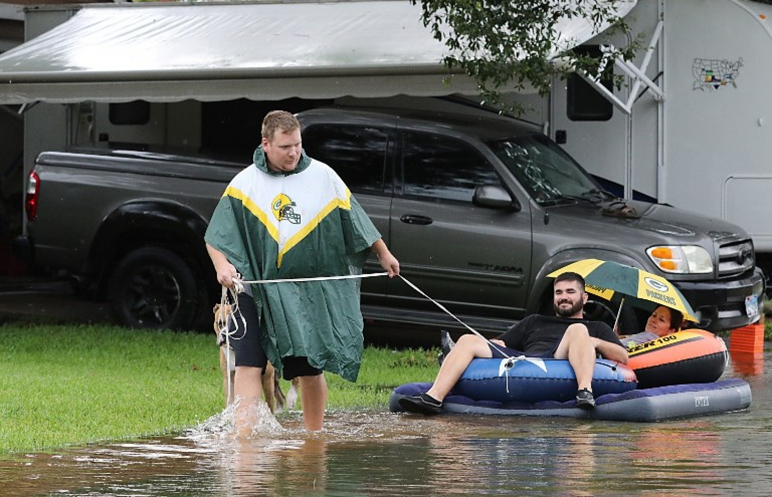 ޓެކްސަސްގައި ފެންބޮޑުވެފައިވާ ހިސާބަކުން ރާފްޓެއްގައި ބަޔަކު ގެންދަނީ. --ފޮޓޯ:އޭއެފްޕީ