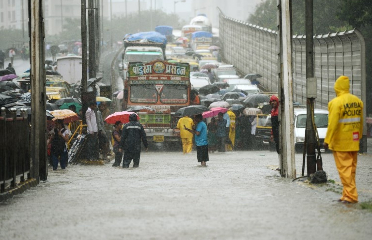 އިންޑިއާގެ މުމްބާއީ އަށް ކުރަމުންދާ ބޯ ވިއްސާރައިގައި ފެންބޮޑުވެފައިވާ މަގަކުން މީހުން ހިނގައިފައި ދަނީ. --ފޮޓޯ:އޭއެފްޕީ