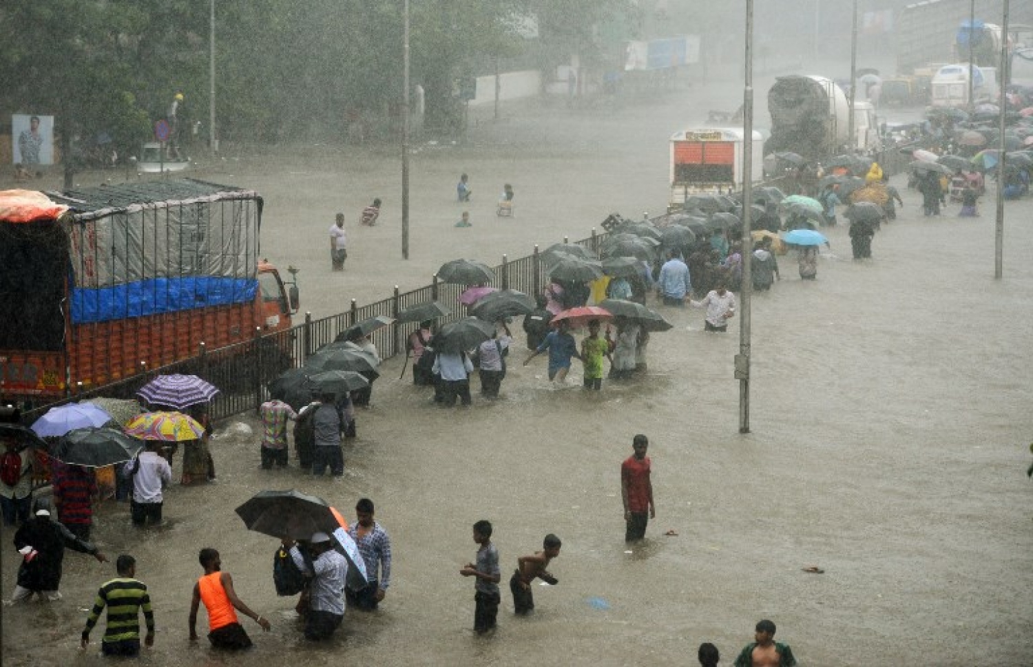 އިންޑިއާގެ މުމްބާއީ އަށް ކުރަމުންދާ ބޯ ވިއްސާރައިގައި ފެންބޮޑުވެފައިވާ މަގަކުން މީހުން ހިނގައިފައި ދަނީ. --ފޮޓޯ:އޭއެފްޕީ