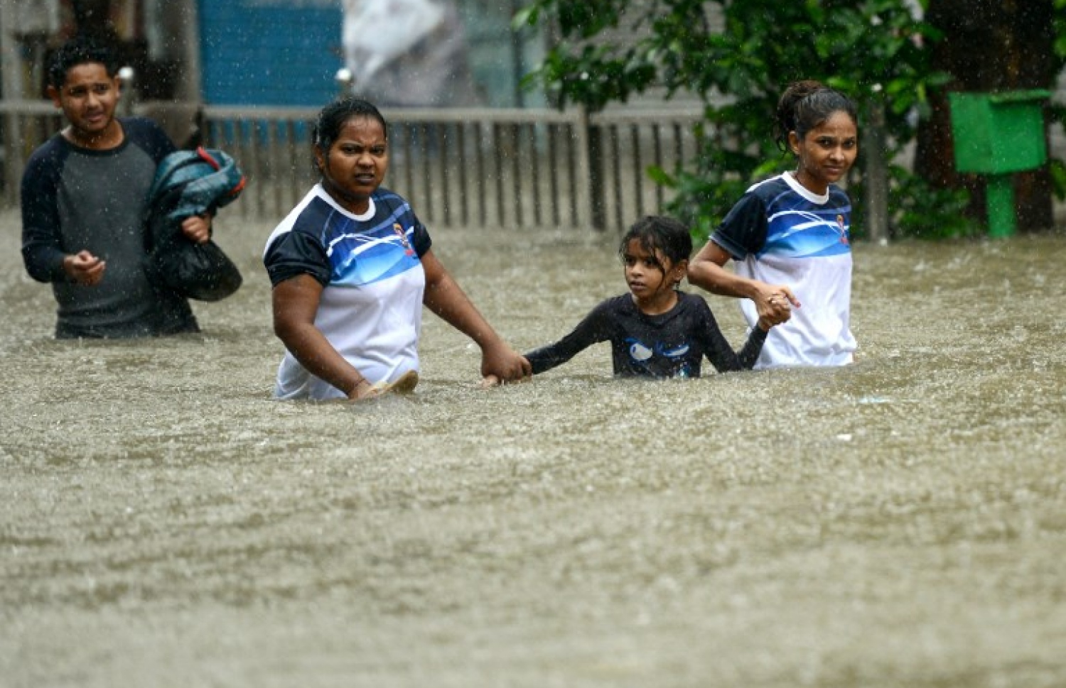 މުމްބާއީގެ ފެންބޮޑުވެފައިވާ ސަރަހައްދަކުން ކުދިންތަކެއް ހިނގާފައި ދަނީ. --ފޮޓޯ:އޭއެފްޕީ