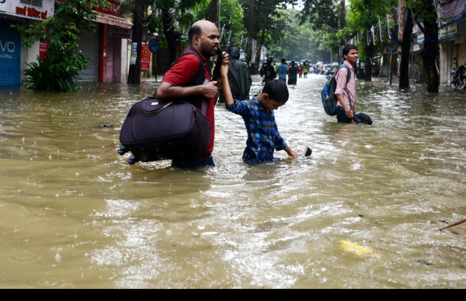 ބޯވިއްސާރައިގައި މުމްބާއީގައި ފެންބޮޑުވެފައިވާ ސަރަހައްދަކުން ކުދިންތަކެއް ހިނގާފައި ދަނީ. --ފޮޓޯ:އޭއެފްޕީ