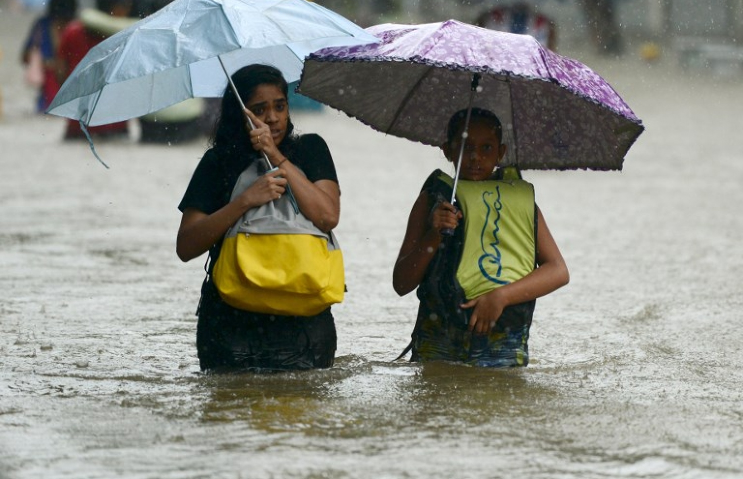 މުމްބާއީގެ ފެންބޮޑުވެފައިވާ ސަރަހައްދަކުން ކުދިންތަކެއް ހިނގާފައި ދަނީ. --ފޮޓޯ:އޭއެފްޕީ