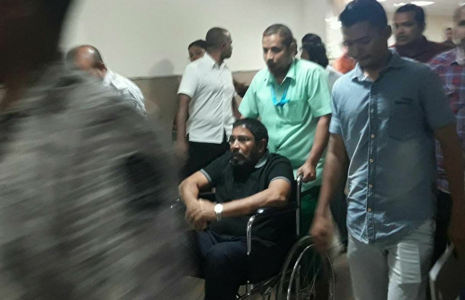 ގާސިމް މިރޭ ފުރާވަޑައިގަތުމަށްޓަކައި އެމްބިއުލާންސަށް އަރާވަޑައިގަތުމަށް އައިޖީއެމްއެޗުގައި ފުރޮޅުލީގޮނޑިއެއްގައި ގެންދަނީ.