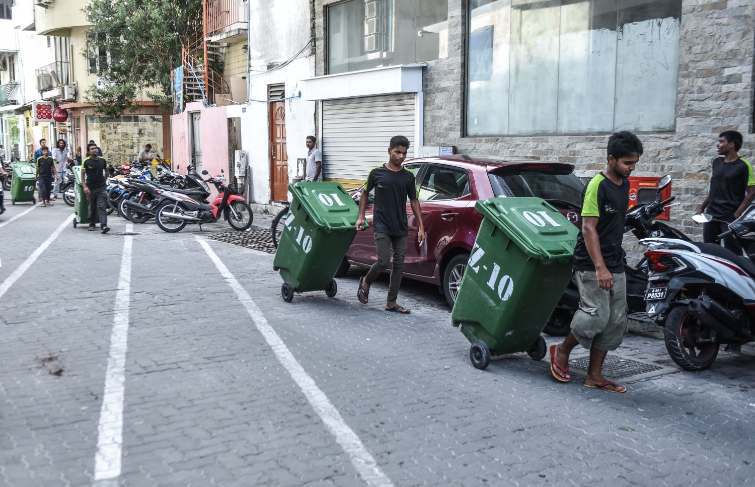 މާލެ އިން ކުނިއުކާލުމަށްޓަަކައި ވެމްކޯގެ މުވައްޒަފުން ޑަސްބިންތަކެއް ހިފައިގެން ދަނީ.---މިހާރު ފޮޓޯ: ހުސެއިން ވަހީދު