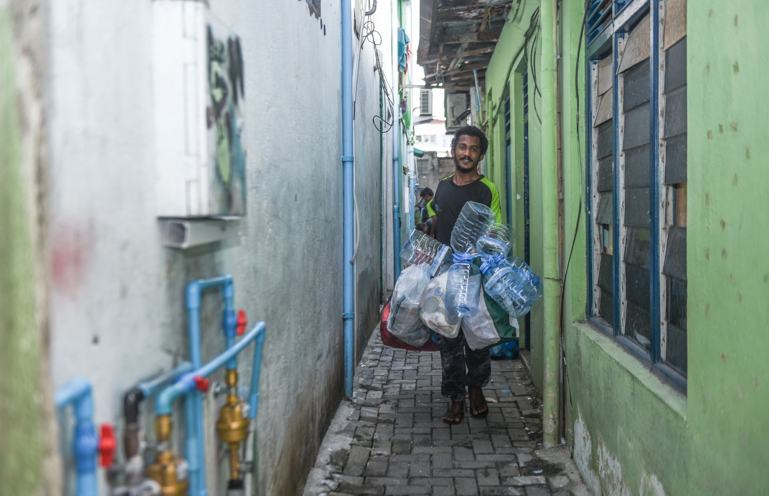 މާލޭގެ ގެއަކުން އުކާލާ ކުނިތަކެއް ހިފައިގެން ވެމްކޯގެ މުވައްޒަފަކު ދަނީ.---މިހާރު ފޮޓޯ: ހުސެއިން ވަހީދު