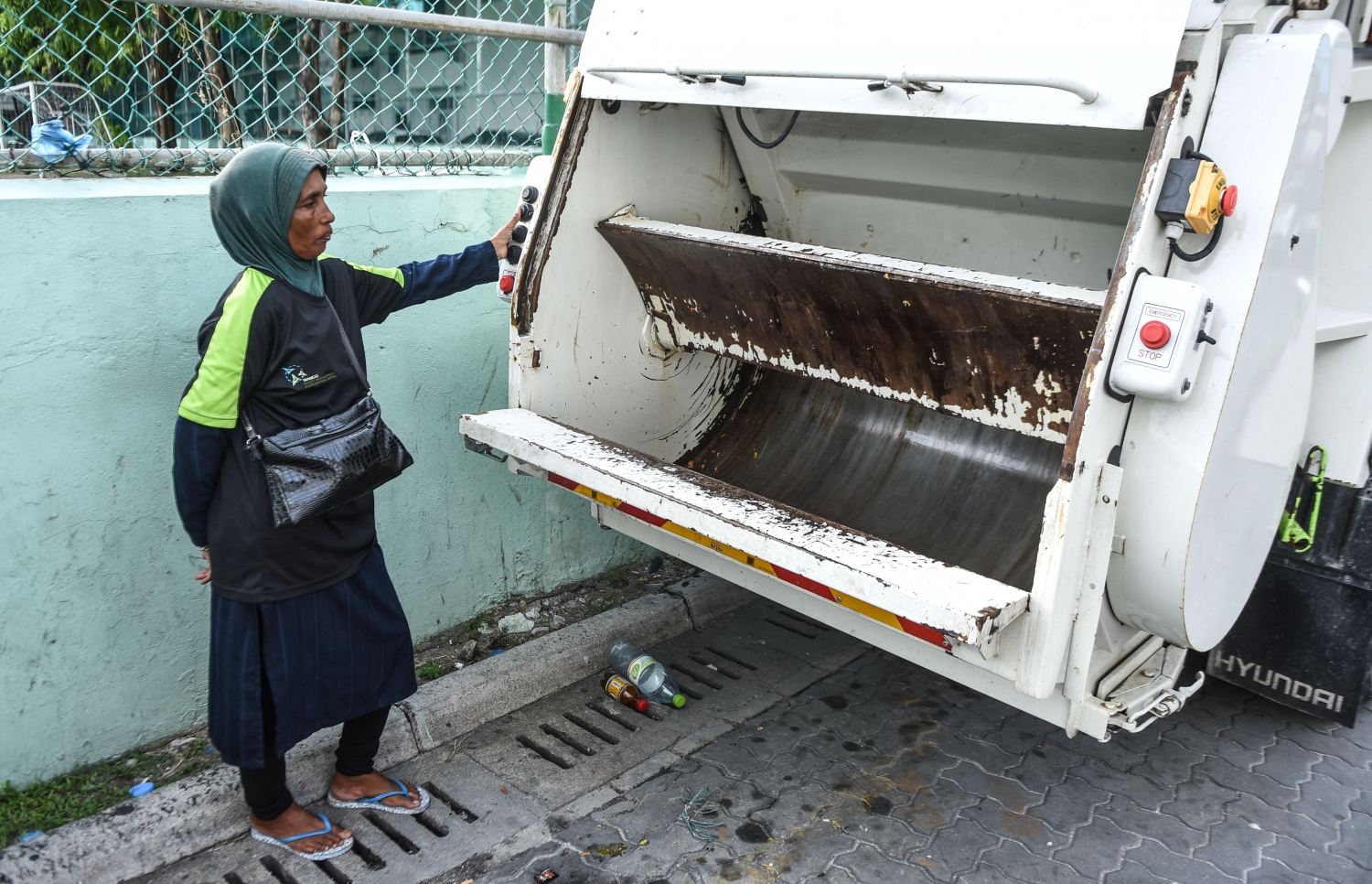 މާލެ އިން ކުނި އުކާލުމަށް ހަރަކާތްތެރިވާ ވެމްކޯގެ އަންހެން މުވައްޒަފަކު، ކުނި އުފުލާ ވެހިކަލެއްގެ ކައިރީގައި މަޑުކޮށްލައިގެން.---މިހާރު ފޮޓޯ: ހުސެއިން ވަހީދު