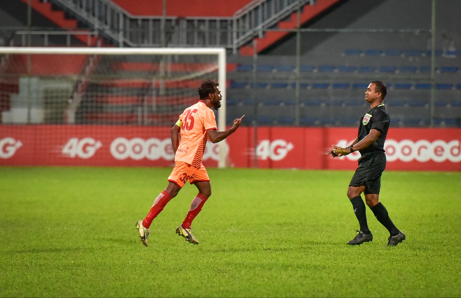 ގްރީންސްޓްރީޓްސްގެ ކެޕްޓަން ސައްޕޭ (ވ) ރެފްރީގެ ފަހަތުން ދަނީ. --ފޮޓޯ: ނިޝާން އަލީ/ މިހާރު