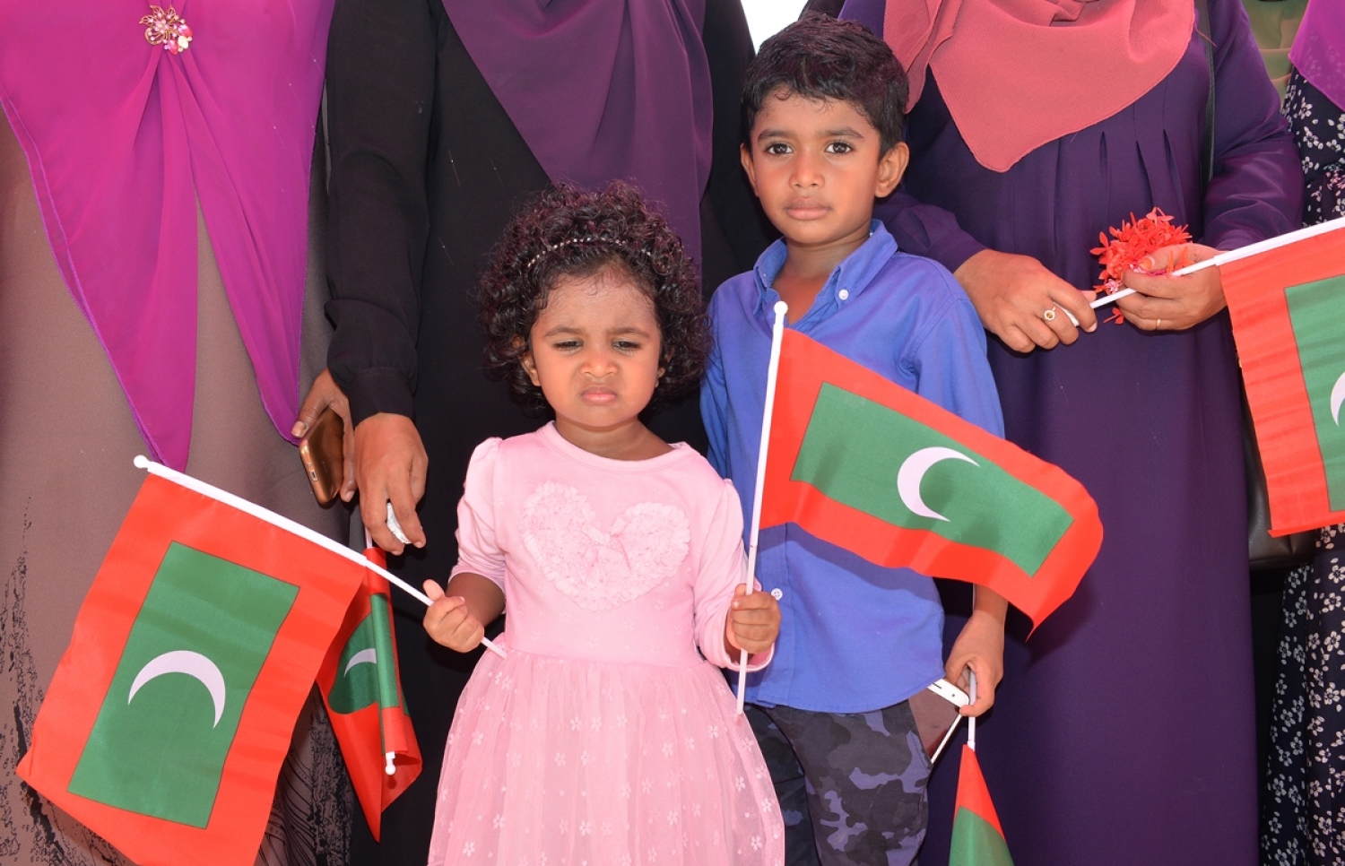 ގއ. ކޮލަމާފުށި: ސެޕްޓެމްބަރު 26، 2017- ރައީސް އަބްދުﷲ ޔާމީންގެ ދެކަނބަލުން ކޮލަމާފުއްޓަށް ވަޑައިގަންނަވާތީ، އެ ދެކަނބަލުންނަށް މަރުހަބާ ދެންނެވުމަށް ގެންދިޔަ ކުޑަދެކުއްޖަކު ގައުމީ ދިދަ ހިފައިގެން.---ފޮޓޯ: ރައީސް އޮފީސް