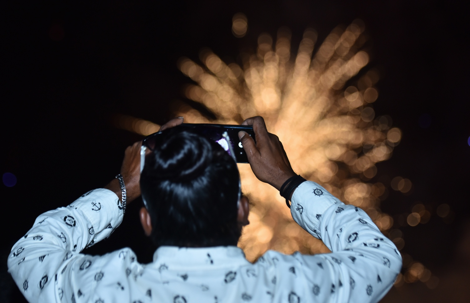 ހުޅުމާލެ ފޭސް 2: ނޮވެމްބަރު 18، 2017- ގާތްގަނޑަކަށް 80،000 މީހުންނަށް އަމާޒުކޮށް ހުޅުމާލޭގެ ދެވަނަ ފިޔަވަހީގައި ފްލެޓް އެޅުމުގެ ބިޔަ މަޝްރޫއު އިފްތިތާހު ކުރުން ފާހަގަކުރުމަށް ބޭއްވި ރަސްމިއްޔާތުގައި ހަވާ އަރުވާއިރު، މީހަކު އެ މަންޒަރު ފޯނުން ފޮޓޯ ނަގަނީ.---ފޮޓޯ: ހުސެއިން ވަހީދު/މިހާރު