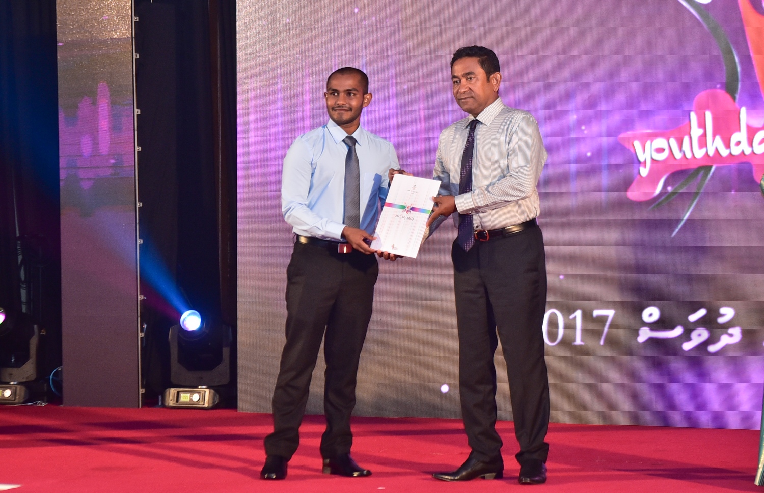 މާލެ: ނޮވެމްބަރު 26، 2017- މި އަހަރުގެ ޒުވާނުންގެ އެވޯޑް ހާސިލްކުރި މީހަކާ ރައީސް ޔާމީން މިރޭ އެވޯޑް ހަވާލުކޮށް ދެއްވަނީ: މި އަހަރުގެ ޒުވާނުންގެ އެވޯޑް އަށް މީހަކަށް ރައީސް ޔާމީން ދެއްވި.---ފޮޓޯ: ހުސެއިން ވަހީދު/މިހާރު