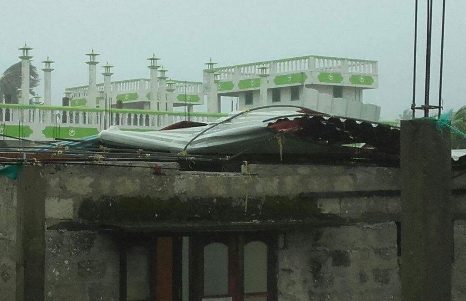 މަލިކު: ޑިސެމްބަރު 3، 2017: ބާރުގަދަ ކޮޅިގަނޑުގައި މަލިކުގެ ގެއެއްގެ ފުރާޅު ބާރުވަޔާއެކު އެއްލާލާފައި.