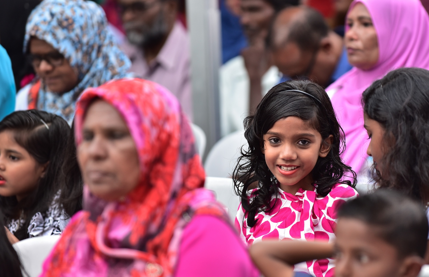 ހުޅުމާލެ: ޑިސެމްބަރު 4، 2017- ޗައިނާ މެޝިނަރީ އިންޖީނިއަރިން ކޯޕަރޭޝަން (ސީއެމްއީސީ) އިން ހުޅުމާލެ އާއި ރާއްޖޭގެ ދެކުނުގެ އަށް ރަށެއްގައި އިމާރާތްކުރި 1،500 ހައުސިން ޔުނިޓް ދިވެހި ސަރުކާރާ ހަވާލުކުރުމަށް ބޭއްވި ރަސްމިއްޔާތަށް ދިޔަ ކުޑަކުއްޖަކު ކެމެރާ އަށް ބަލަހައްޓައިގެން.---ފޮޓޯ: ހުސެއިން ވަހީދު/މިހާރު