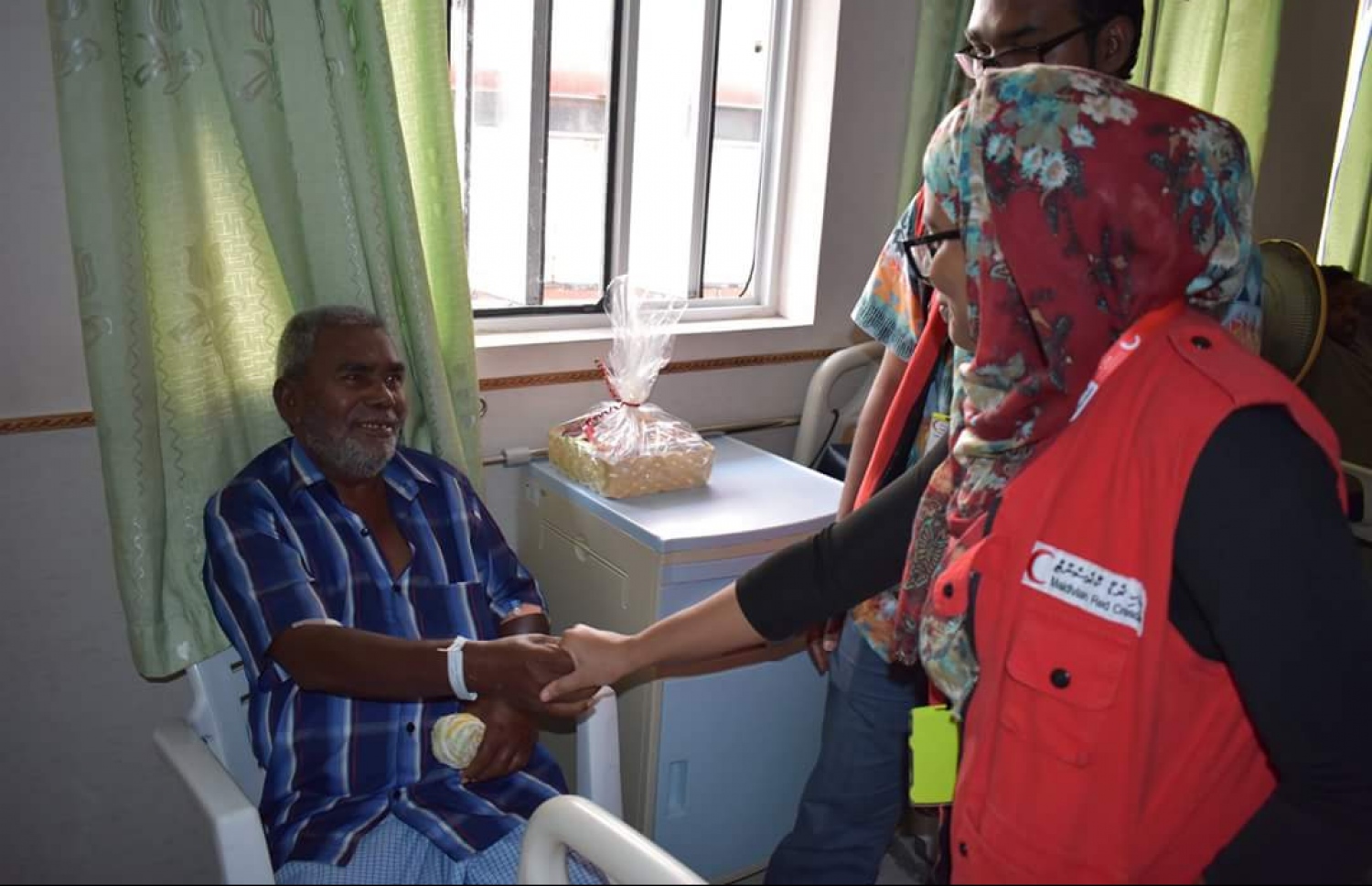 އެމްއާރުސީގެ ވޮލަންޓިއަރަކު އުމުރުން ދުވަސްވީ މީހަކާ ސަލާމްކުރަނީ. ފޮޓޯ: އެމްއާރުސީ