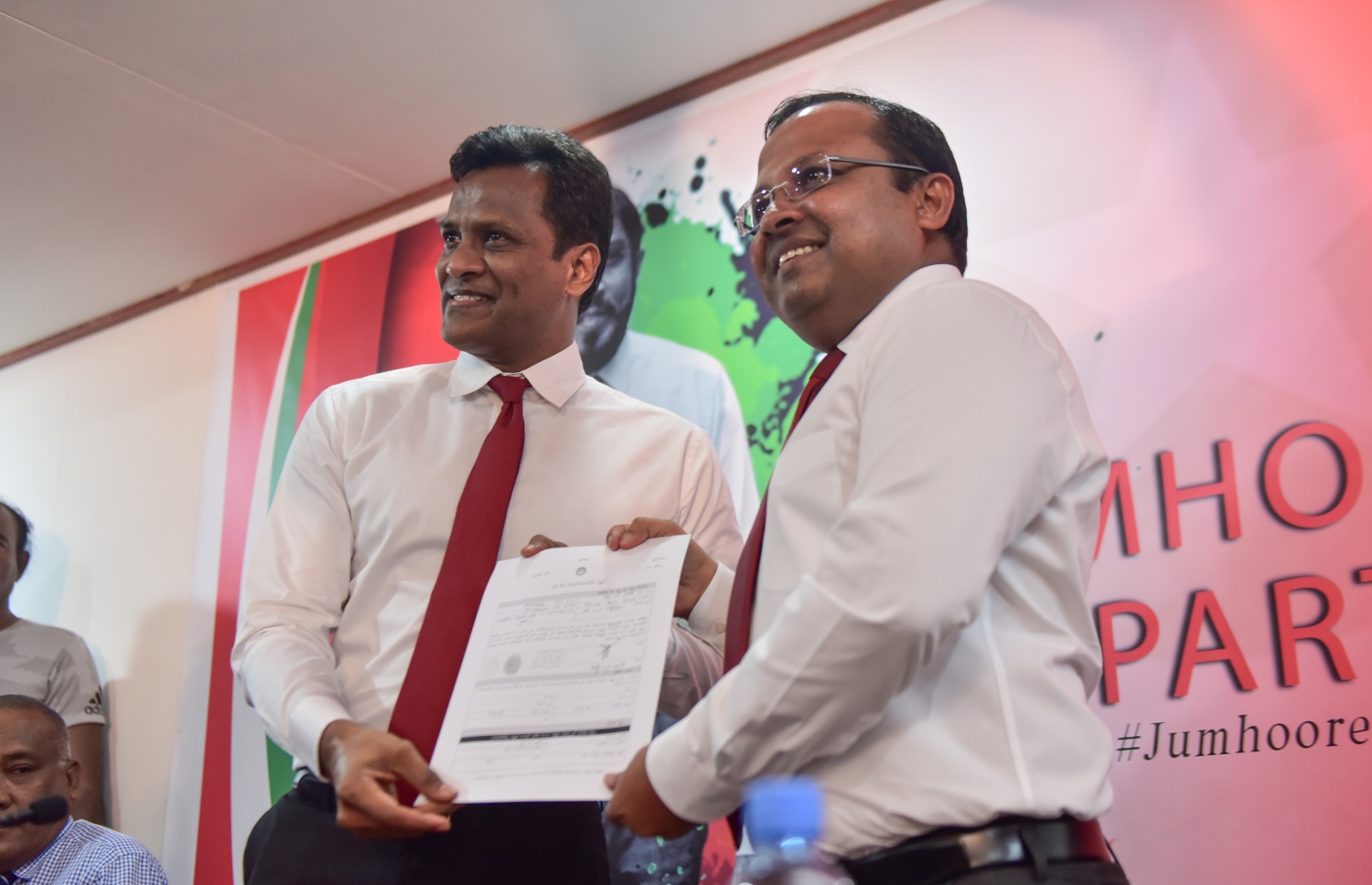 އުމަރު ޖޭޕީއަށް ސޮއިކުރެއްވުމަށް ފަހު، ފޯމު އެ ޕާޓީގެ ޑެޕިއުޓީ ލީޑަރު އަބްދުﷲ ރިޔާޒާ ހަވާލުކުރައްވަނީ. ---ފޮޓޯ: ހުސެއިން ވަހީދު/ މިހާރު