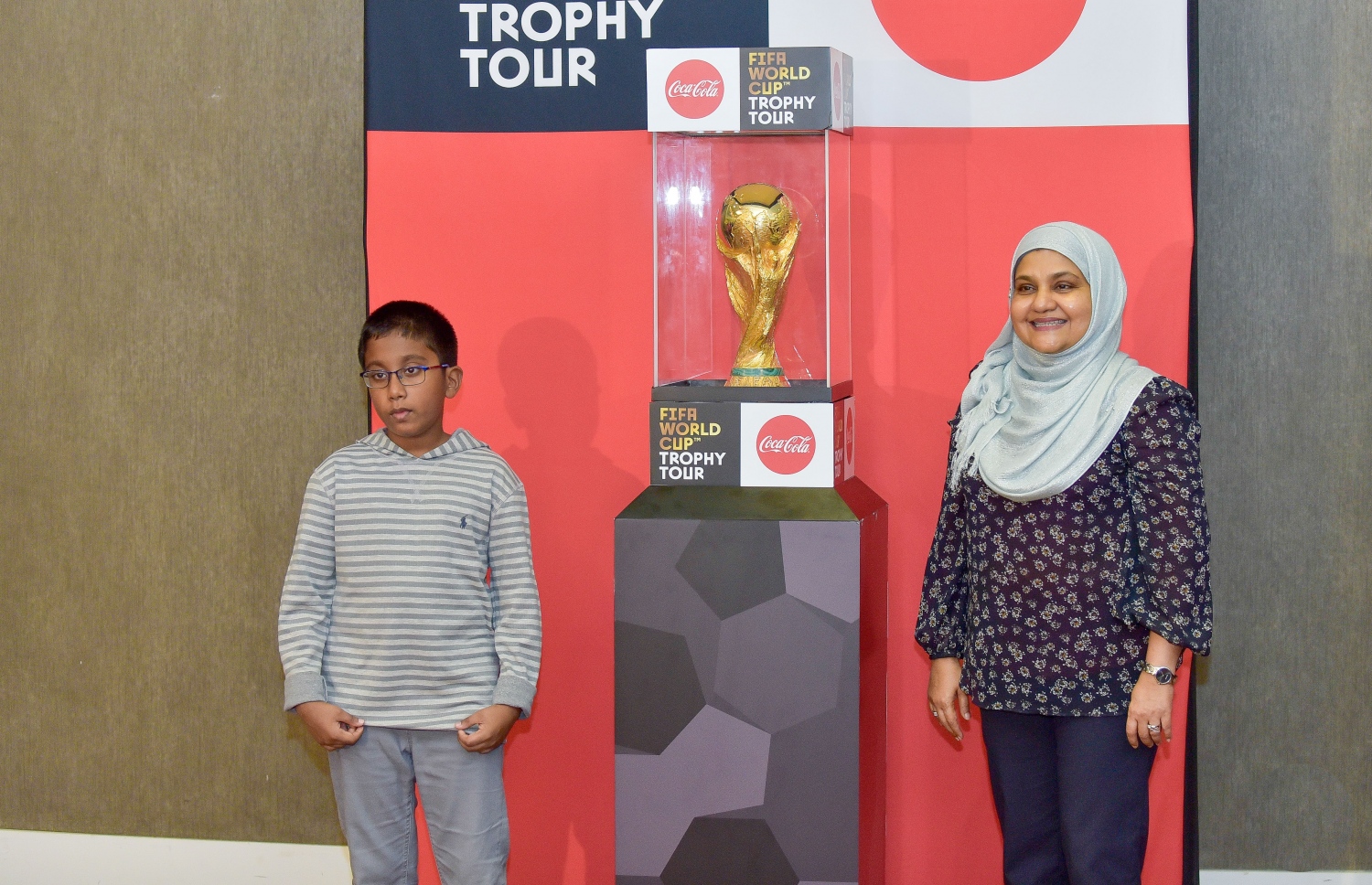 ޖެނުއަރީ 24، 2018- މި އަހަރުގެ ފީފާ ވޯލްޑް ކަޕްގެ ތަށި ގެނައުމުން މަރުހަބާ ކިޔުމަށް ވެލާނާ އިންޓަނޭޝަނަލް އެއާޕޯޓުގައި ބޭއްވި ހަފުލާގައި ފަސްޓް ލޭޑީ ފާތިމަތު އިބްރާހީމާއި ދަރިކަލުން އެ ތަށި ކައިރީގައި ފޮޓޯފުޅެއް ނަންގަވަނީ.---ފޮޓޯ: ނިޝާން އަލީ/މިހާރު