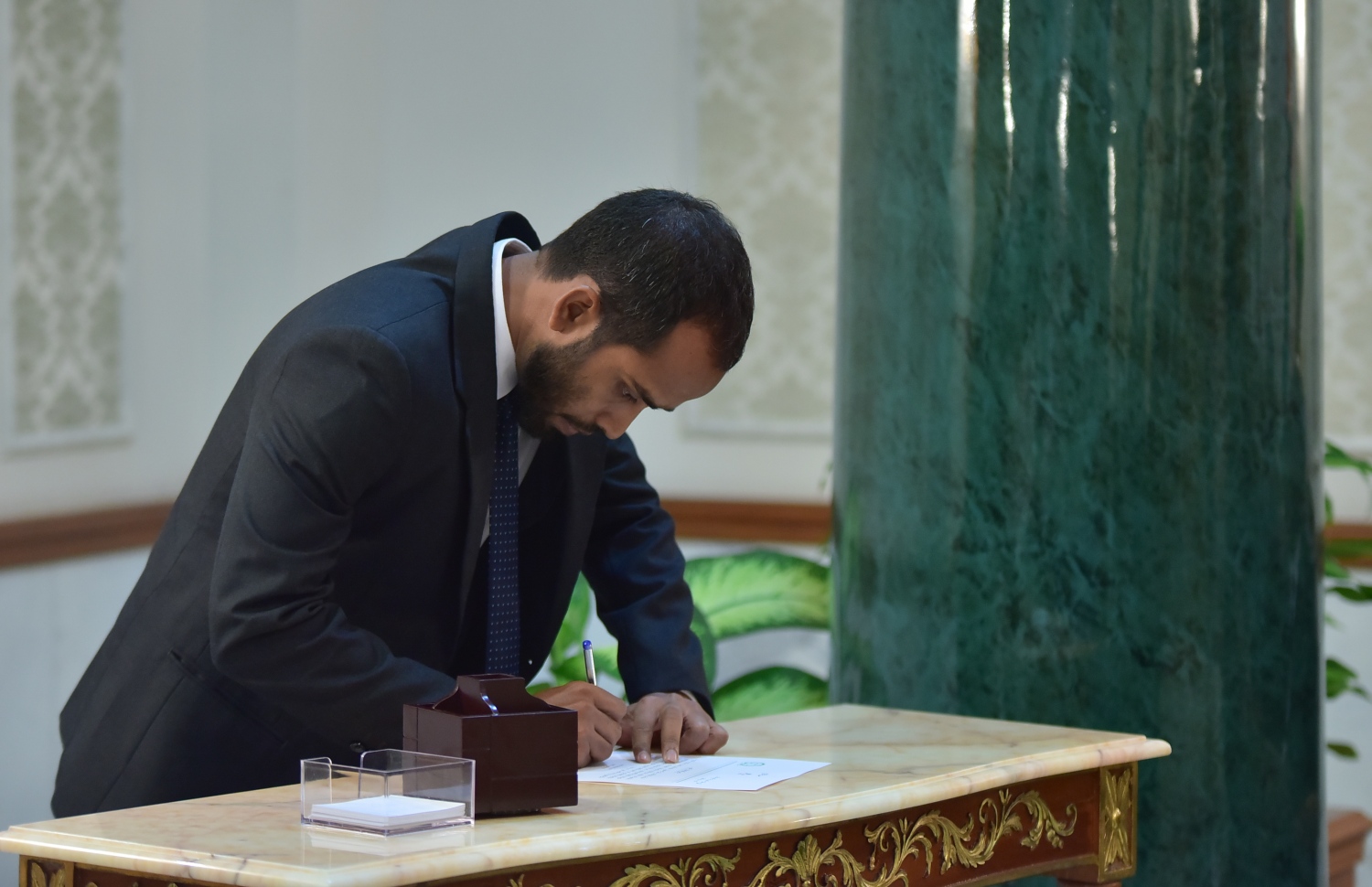 މާލެ: ޖެނުއަރީ 25، 2018- ކްރިމިނަލް ކޯޓަށް އަލަށް އައްޔަން ކުރެއްވި ދެ ފަނޑިޔާރުންގެ ތެރެއިން އަހުމަދު ހައިލަމް، މަގާމުގެ ލިޔުމުގައި ސޮއިކުރައްވަނީ.---ފޮޓޯ: ހުސައިން ވަހީދު/މިހާރު