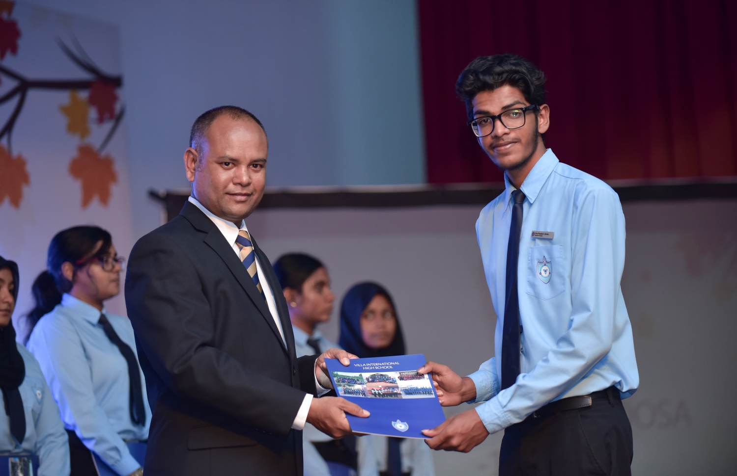 ވިލާ ހައި ސްކޫލުން ދަސްވެނިވި ދަރިވަރަަކަށް، އެ ސްކޫލުގެ ޑެޕިއުޓީ ޕްރިންސިޕަލް ނަޝީދު ސެޓްފިކެޓް ހަވާލުކޮށްދެއްވަނީ.-- ފޮޓޯ: ހުސެއިން ވަހީދު/ މިހާރު