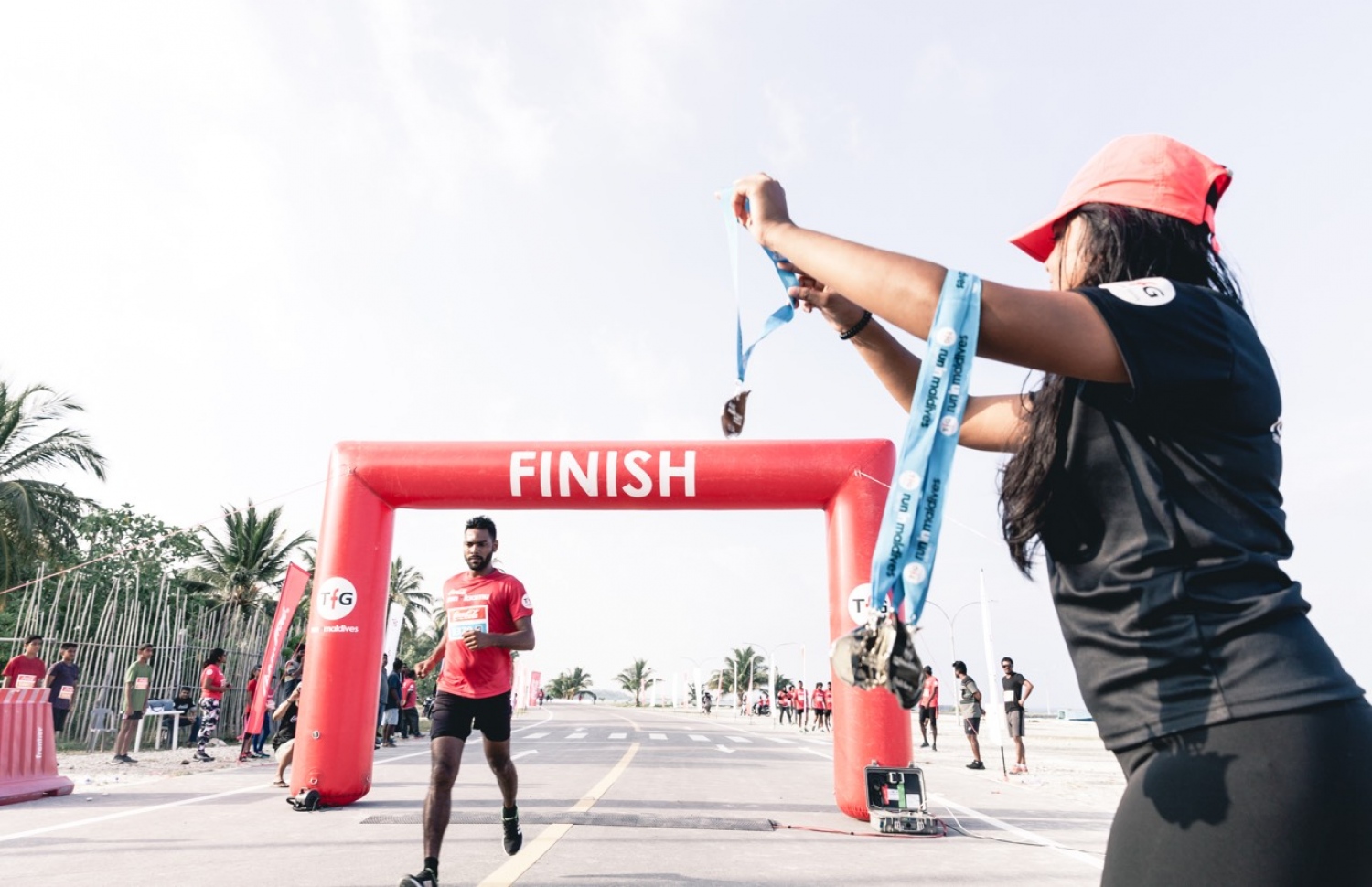 ޓީއެފްޖީން ލ. އަތޮޅުގައި މިއަދު ބޭއްވި "ކޮކާކޯލާ ރަން އިން ލާމު" ރޭސް ނިންމި ބައިވެރިޔަކަށް މެޑަލް ދެނީ. –ފޮޓޯ: ޓީއެފްޖީ. –ފޮޓޯ: ޓީއެފްޖީ