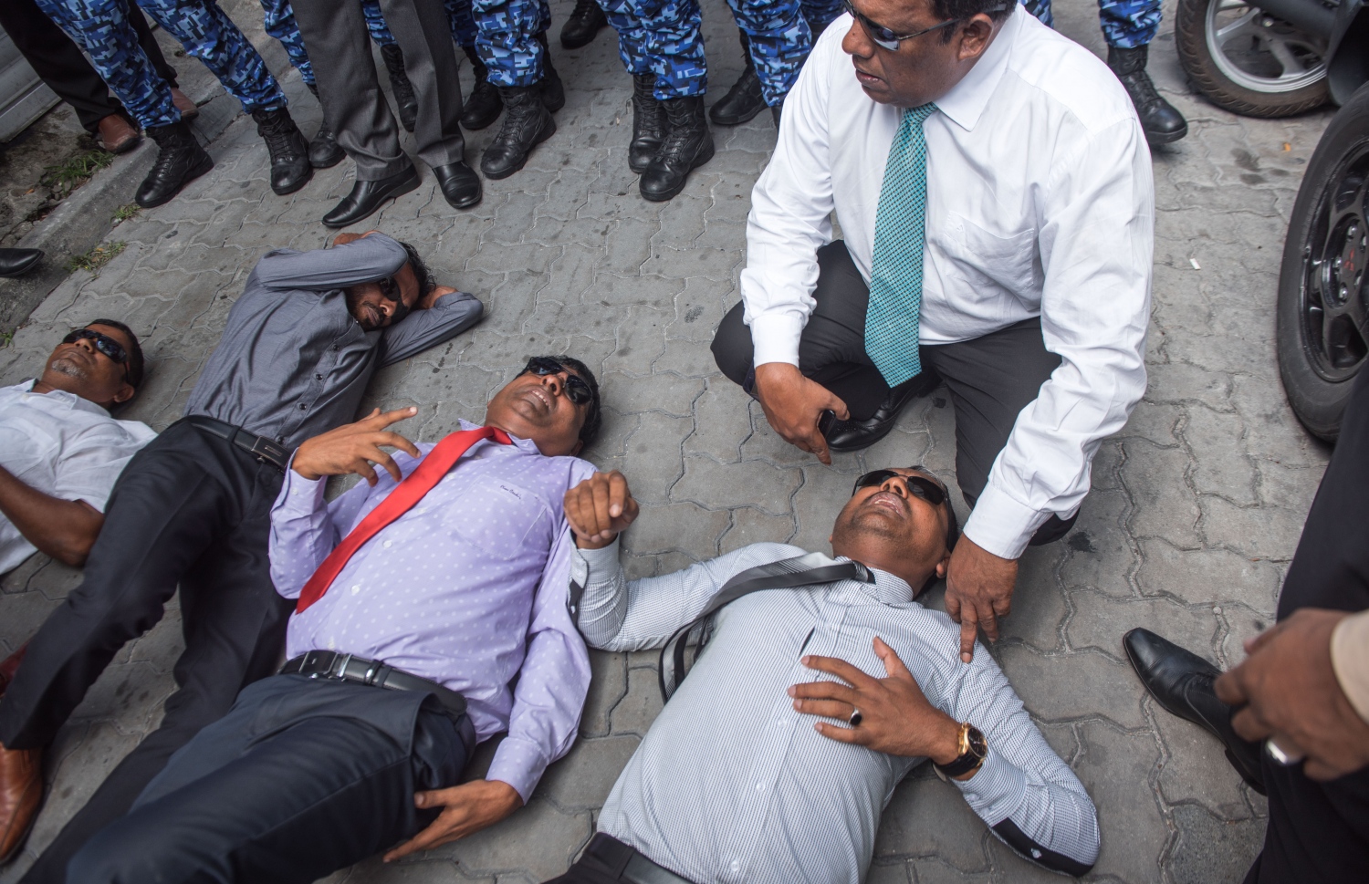 މާލެ: ފެބްރުއަރީ 15، 2018- ރައްޔިތުންގެ މަޖިލީހުގެ އިދިކޮޅު މެމްބަރުން މަޖިލީހުގެ އިދާރާ އަށް ވަދެވަޑައިގަންނަވަން އުޅުއްވުމުން، ފުލުހުންނާ ދެމެދު ހިނގި ހަމަނުޖެހުމުގައި އަނިޔާވި ބައެއް މެމްބަރުން މަޖިލީހުގެ އިދާރާގެ ކައިރީގެ ބިންމަތީގައި.---ފޮޓޯ: ނިޝާން އަލީ/މިހާރު