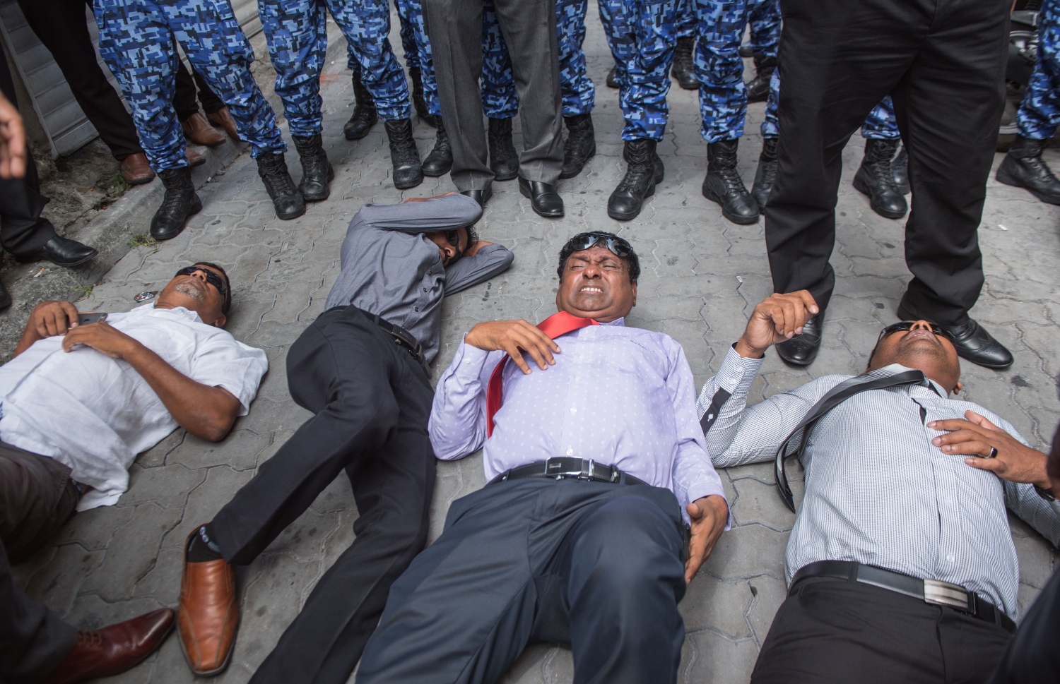 މާލެ: ފެބްރުއަރީ 15، 2018- ރައްޔިތުންގެ މަޖިލީހުގެ އިދިކޮޅު މެމްބަރުން މަޖިލީހުގެ އިދާރާ އަށް ވަދެވަޑައިގަންނަވަން އުޅުއްވުމުން، ފުލުހުންނާ ދެމެދު ހިނގި ހަމަނުޖެހުމުގައި އަނިޔާވި ބައެއް މެމްބަރުން މަޖިލީހުގެ އިދާރާގެ ކައިރީގެ ބިންމަތީގައި.---ފޮޓޯ: ނިޝާން އަލީ/މިހާރު