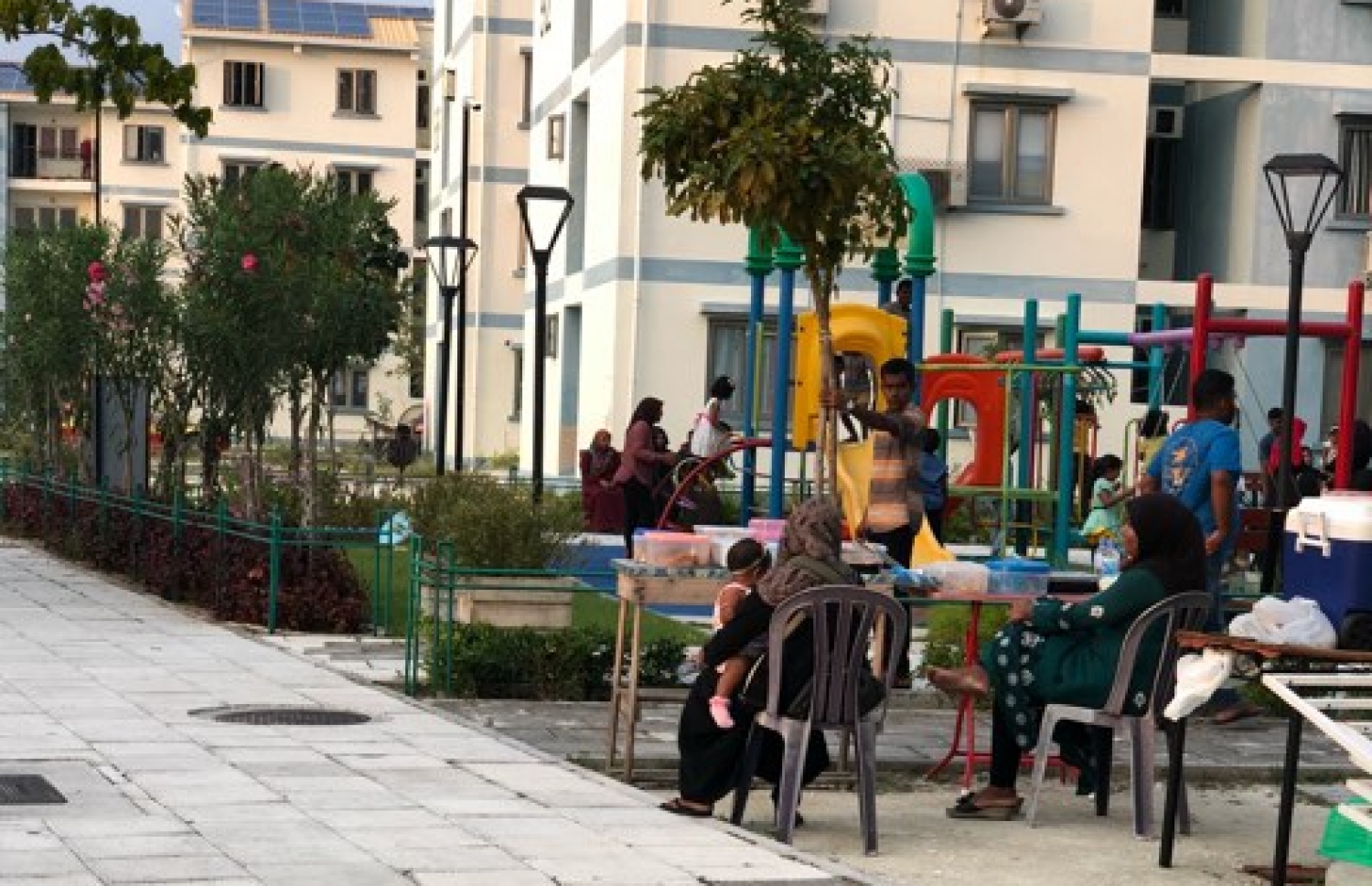 ފްލެޓެއް ކައިރީގައި މޭޒު ބަހައްޓައިގެން ބަޔަކު ހެދިކާ ވިއްކަނީ.