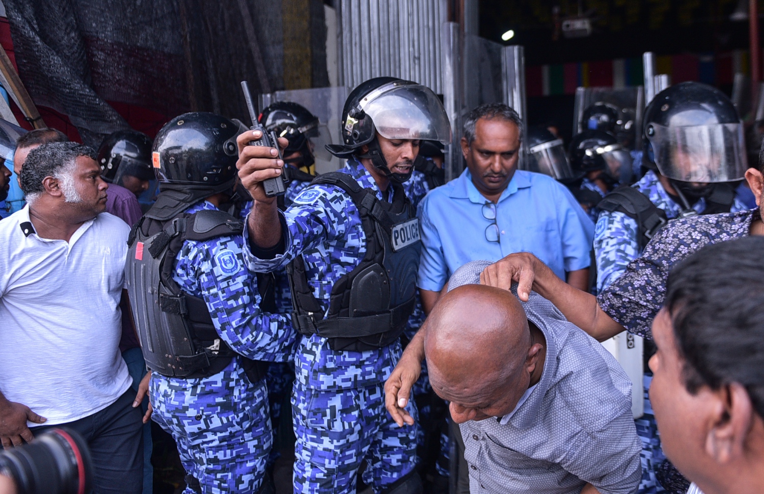 މާލެ: ފެބްރުއަރީ 16، 2018- ސަރުކާރާ ދެކޮޅަށް އިދިކޮޅު ހަރަކާތުން ފަހުގެ ތާރީޚެއްގައި ބާއްވާ ބޮޑު މުޒާހަރާ އަށް ތައްޔާރުވުމަށް "ވޯމްއަޕް މުޒާހަރާ" ގެ ނަމުގައި ކުރިއަށް ގެންދަން އުޅުނު އެއްވުން ރޫޅާލުމުގެ ތެރެއިން، އެސްއޯ ފުލުހުން އެމްޑީޕީގެ ހަރުގެ އިން މީހުން ނެރެނީ.---ފޮޓޯ: ހުސެއިން ވަހީދު/މިހާރު