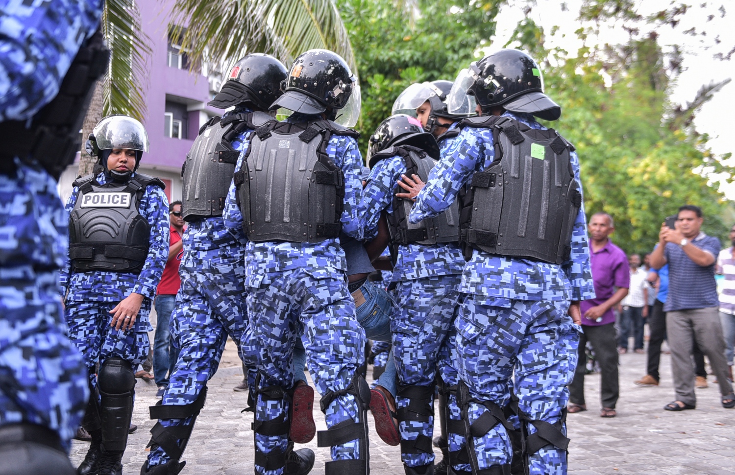 މާލެ: ފެބްރުއަރީ 16، 2018- ސަރުކާރާ ދެކޮޅަށް އިދިކޮޅު ހަރަކާތުން ފަހުގެ ތާރީޚެއްގައި ބާއްވާ ބޮޑު މުޒާހަރާ އަށް ތައްޔާރުވުމަށް "ވޯމްއަޕް މުޒާހަރާ" ގެ ނަމުގައި ކުރިއަށް ގެންދަން އުޅުނު އެއްވުން ފުލުހުން ރޫޅާލައި، އެއްވުމުގެ ބައިވެރިއަކު އެ ސަރަހައްދުން ދުރަށް ގެންދަނީ.---ފޮޓޯ: ހުސެއިން ވަހީދު/މިހާރު