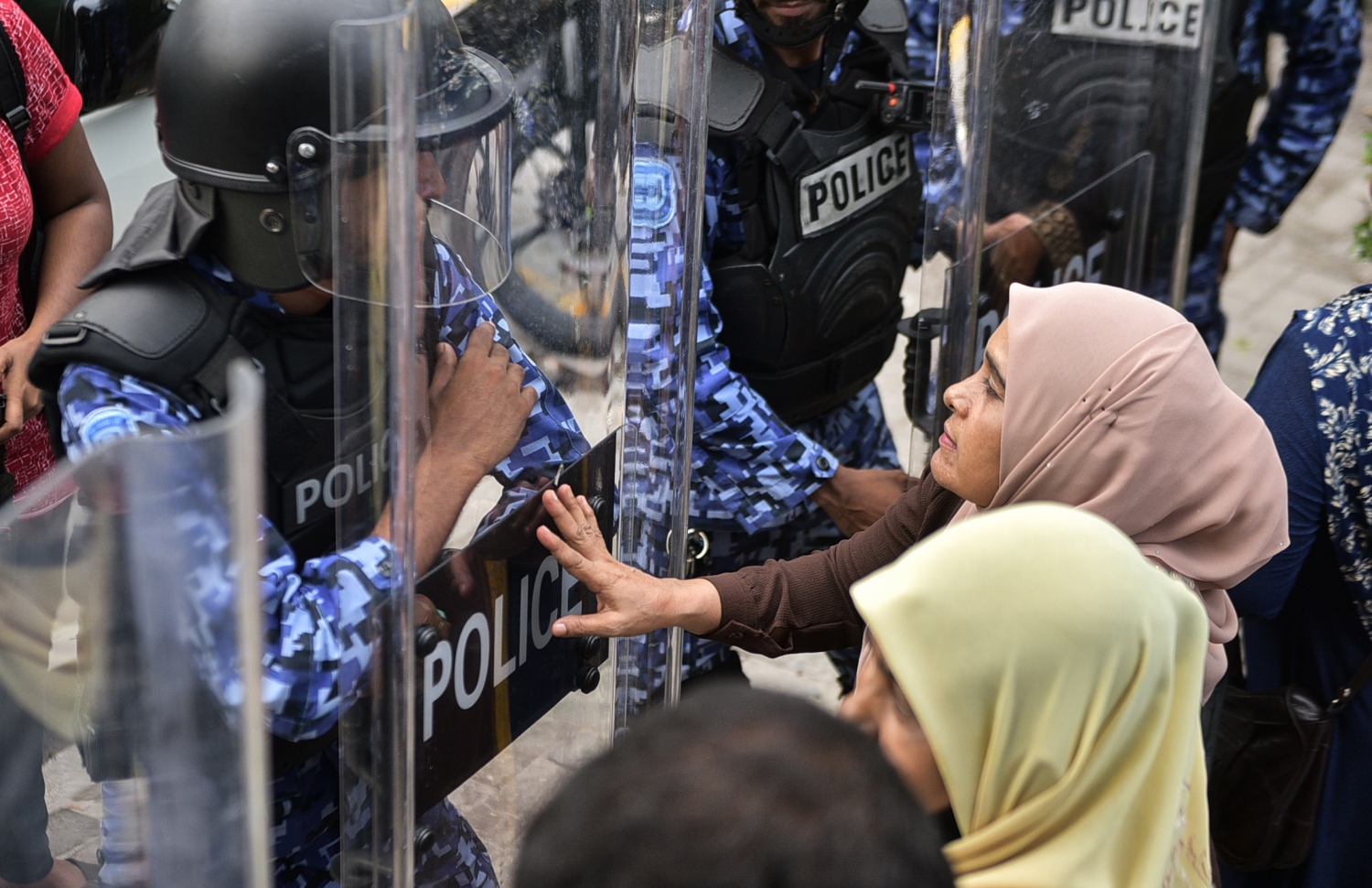 މާލެ: ފެބްރުއަރީ 16، 2018- ސަރުކާރާ ދެކޮޅަށް އިދިކޮޅު ހަރަކާތުން ފަހުގެ ތާރީޚެއްގައި ބާއްވާ ބޮޑު މުޒާހަރާ އަށް ތައްޔާރުވުމަށް "ވޯމްއަޕް މުޒާހަރާ" ގެ ނަމުގައި ކުރިއަށް ގެންދަން އުޅުނު އެއްވުން ރޫޅާލުމަށް އެސްއޯ ފުލުހުން ޝީލްޑާއެކު ތައްޔާރަށް ތިބިއިރު، އެއްވުމުގެ އަންހެން ބައިވެރިއަކު ފުލުހުންނާ ވާހަކަ ދައްކަނީ.---ފޮޓޯ: ހުސެއިން ވަހީދު/މިހާރު