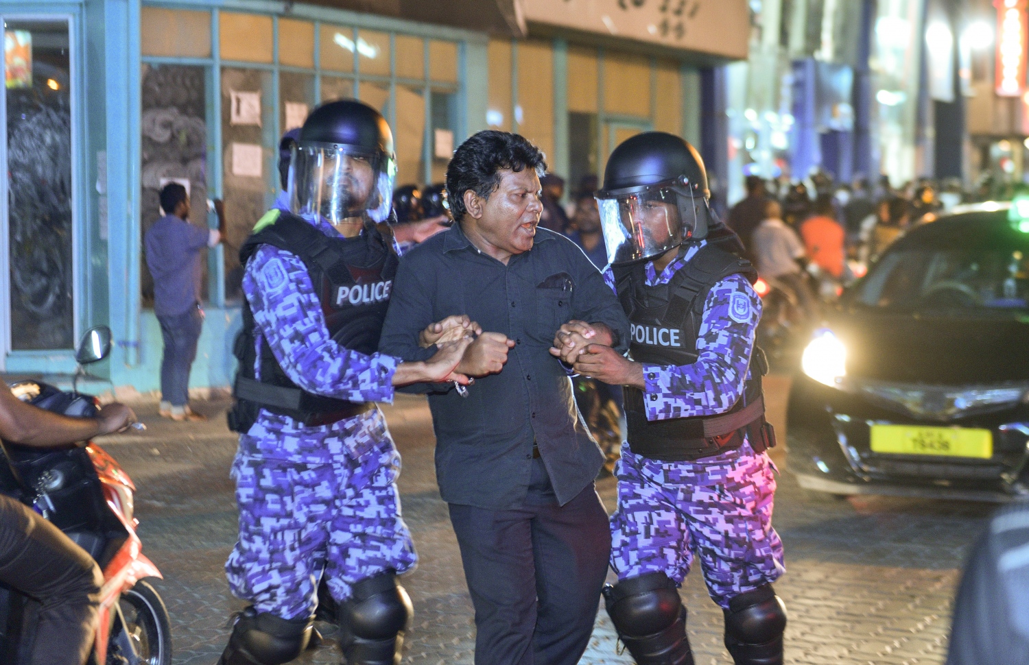 މާލެ: ފެބްރުއަރީ 16، 2018- އިދިކޮޅު ފަރާތްތަކުން މިރޭ މާލޭގައި ބޭއްވި އެއްވުން މަޖީދީ މަގާއި ޗާންދަނީ މަގު ގުޅުނު ސަރަހައްދުން ރޫޅާލައި، އެއްވުމުގެ ބައިވެރިއަކު ފުލުހުން ހައްޔަރުކުރަނީ.---ފޮޓޯ: ހުސެއިން ވަހީދު/މިހާރު