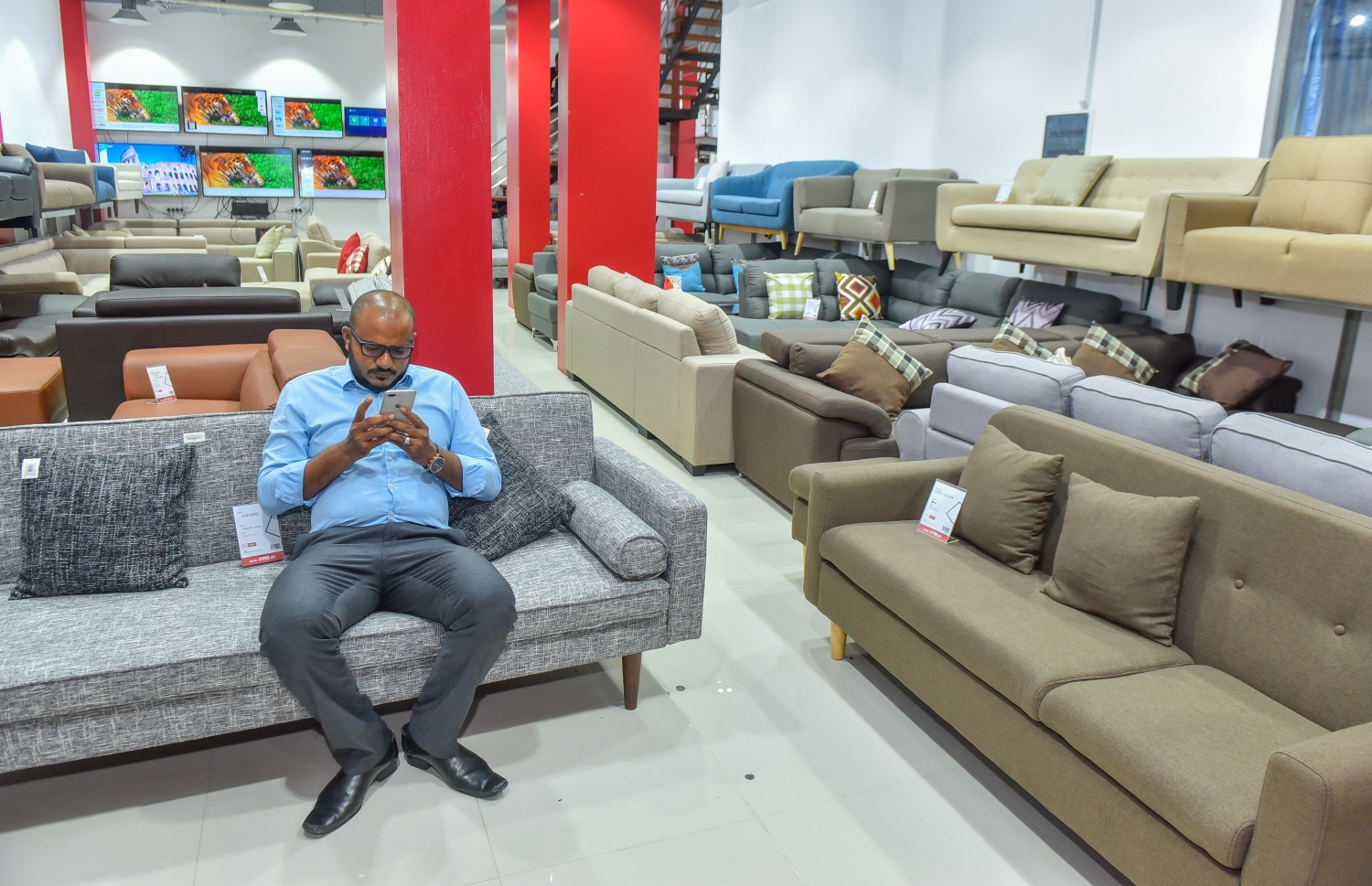 މާލެ: ފެބްރުއަރީ 22، 2018- ފަރުނީޗަރު ވިއްކުމަށް ޚާއްސަ ކޮށްގެން ރެޑް ވޭވުން މިރޭ ހުޅުވި 'ރެޑްވޭވް ލިވިން' ގައި އެތަނުގެ ޖެނެރަލް މެނޭޖަރު އަދި ބާރަށު ދާއިރާގެ މެމްބަރު ޝުޖާއު ގޮނޑިއެއްގައި އިށީނދެވަޑައިގެން މޮބައިލް ފޯނު ބައްލަވަނީ.---ފޮޓޯ: ނިޝާން އަލީ/މިހާރު