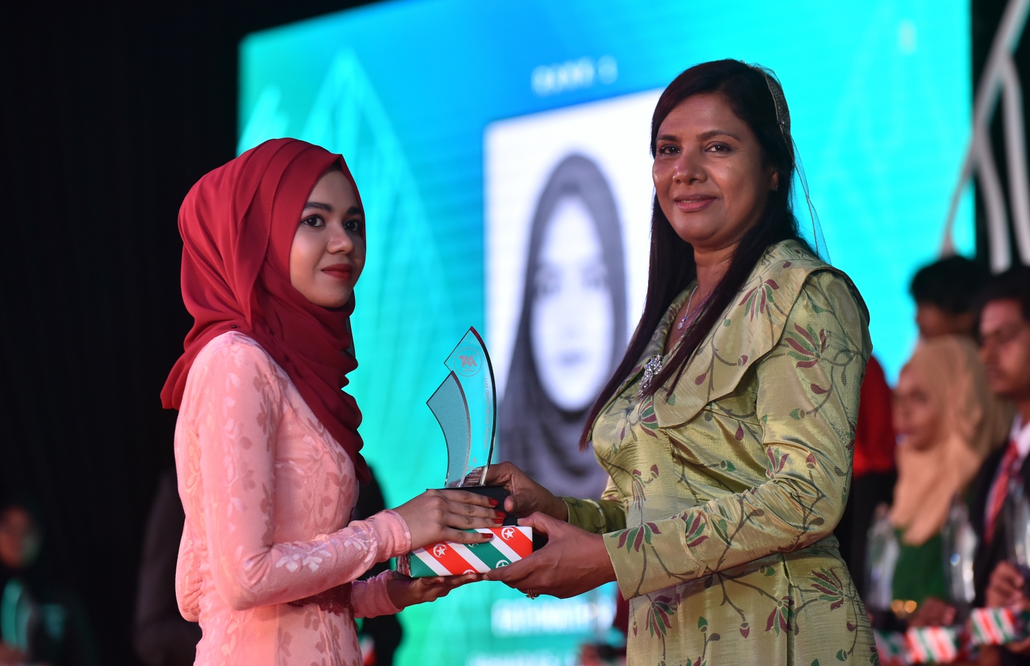 އޭ ލެވެލްގެ ގަދަ 10 އަކަށް އިނާމު ދޭން ބޭއްވި ޖަލްސާގައި، އެޑިއުކޭޝަން މިނިސްޓަރު ޑރ. އައިޝަތު ޝިހާމް ދަރިވަރަކާ އިނާމު ހަވާލުކުރަނީ. --ފޮޓޯ: ހުސެއިން ވަހީދު/މިހާރު