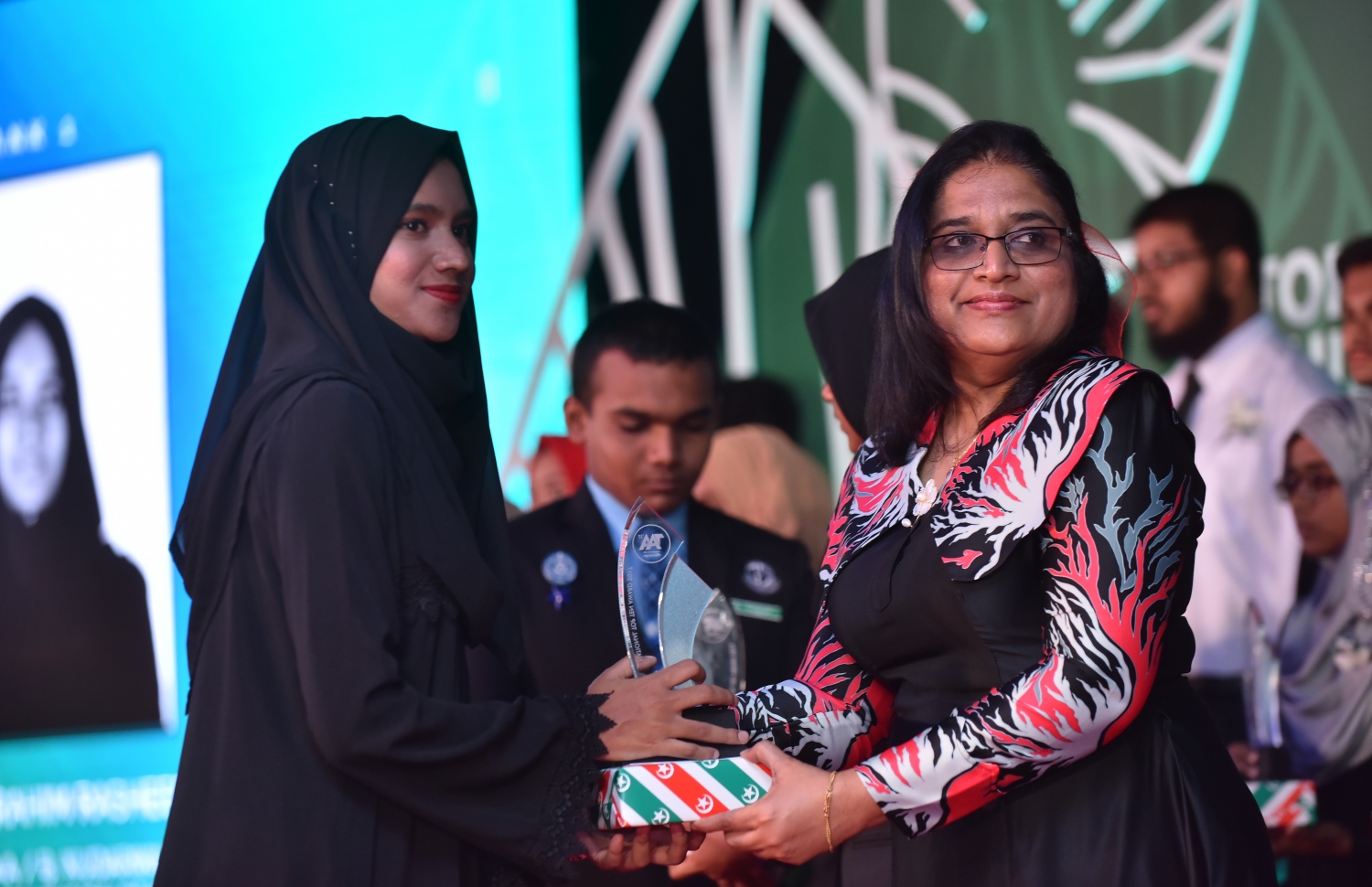 މާލެ: މާޗް 4، 2018- މިދިޔަ އަހަރުގެ އޭ ލެވެލް އިމްތިހާނުގެ ޓޮޕް އެޗީވާސް އެވޯޑް ދިނުމުގެ ރަސްމިއްޔާތުގައި، ރައީސް އޮފީހުގެ ލީގަލް އެފެއާޒް މިނިސްޓަރު އައިޝަތު އާޒިމާ ޝަކޫރު ދަރިވަރަކަށް އިނާމު ދެއްވަނީ---ފޮޓޯ: ހުސައިން ވަހީދު/މިހާރު