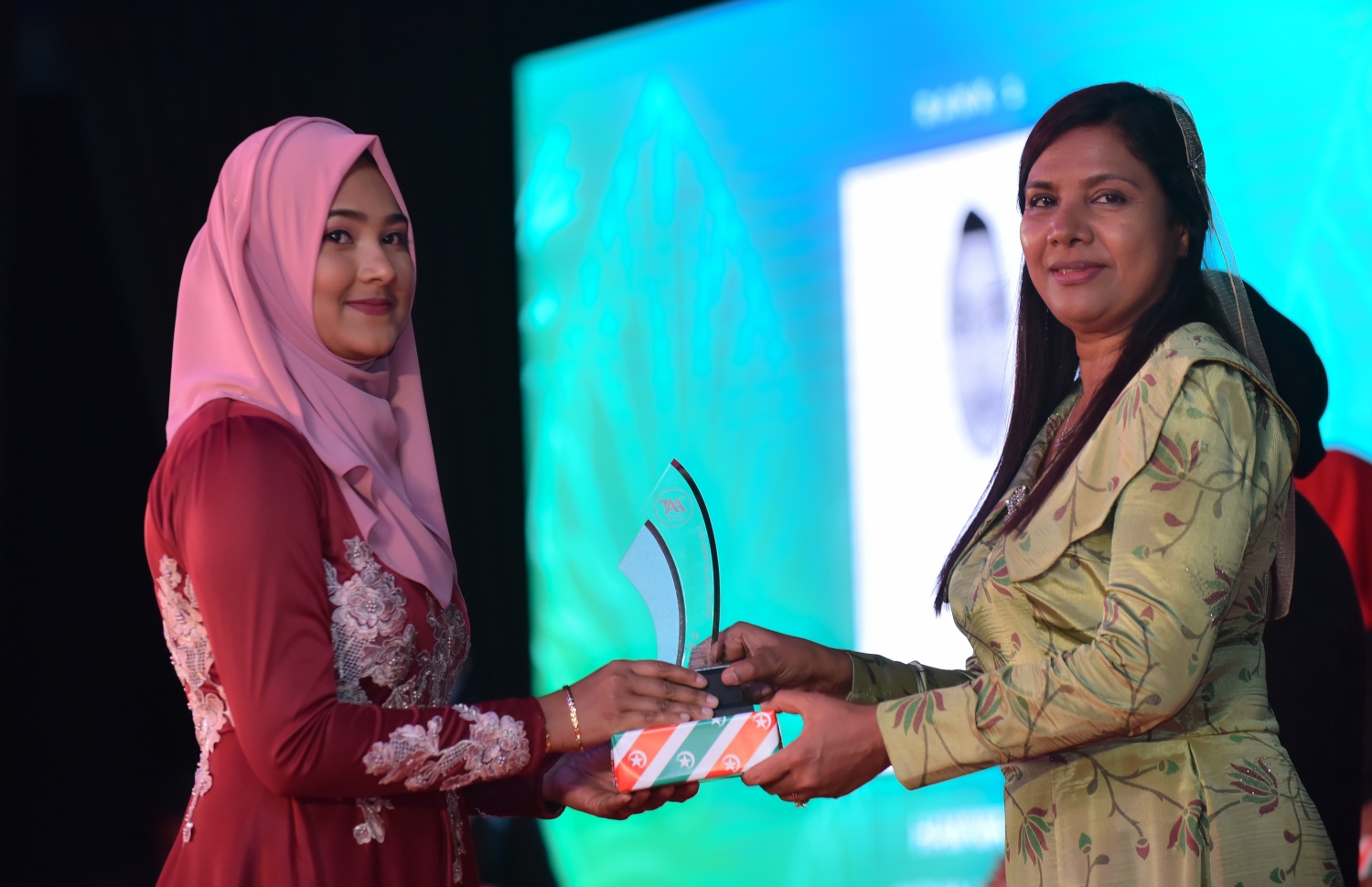 މާލެ: މާޗް 4، 2018- މިދިޔަ އަހަރުގެ އޭ ލެވެލް އިމްތިހާނުގެ ޓޮޕް އެޗީވާސް އެވޯޑް ދިނުމުގެ ރަސްމިއްޔާތުގައި އެޑިއުކޭޝަން މިނިސްޓަރު އައިޝަތު ޝިހާމް ދަރިވަރަކަށް އިނާމު ދެއްވަނީ---ފޮޓޯ: ހުސައިން ވަހީދު/މިހާރު