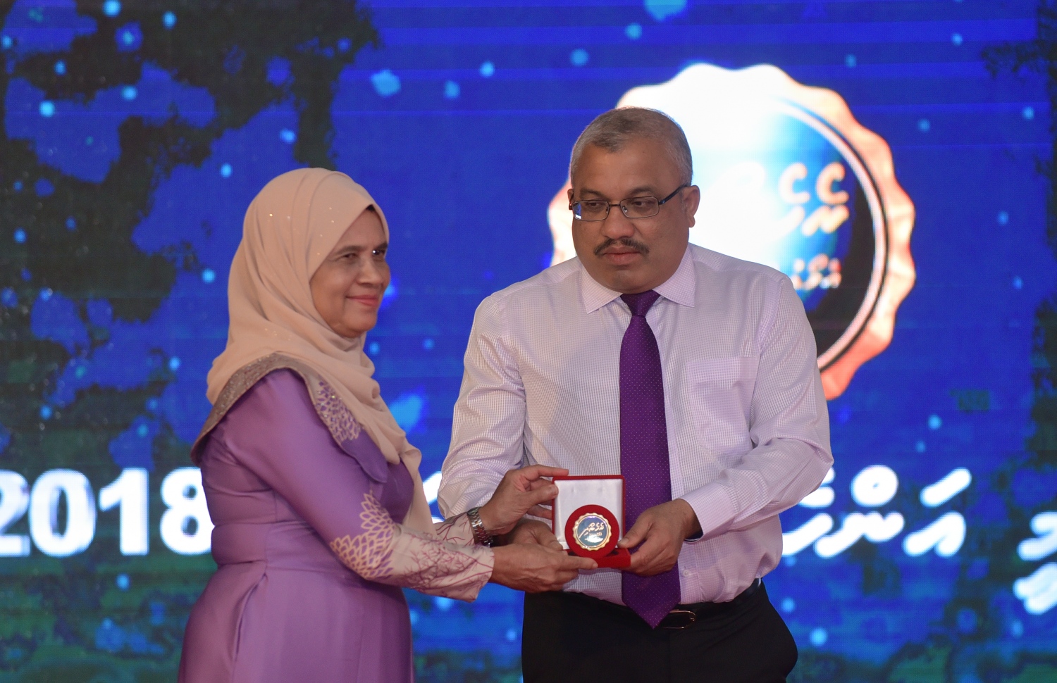 މާލެ: މާޗް 8، 2018- ބައިނަލްއަގުވާމީ އަންހެނުންގެ ދުވަސް ފާހަގަ ކުރުމުގެ ގޮތުން ދަރުބާރު ގޭގައި ބޭއްވި ހާއްސަ ޖަލްސާގައި ނައިބު ރައީސް އަބްދުﷲ ޖިހާދު، ނަރުހެއްގެ ގޮތުގައި ގިނަ ހިދުމަތްތަކެއް ކުރައްވާފައިވާ އައިމިނަތު ވަހީދާއަށް ރެހެންދި އެވޯޑު ދެއްވަނީ: މިޖަލްސާގައި އަންހެނުން ކުރާ މަސައްކަތާއި ޚިދުމަތުގެ އަގު ވަޒަން ކުރުމުގެ ގޮތުން ސަރުކާރުން ދޭ ރެހެންދި އެވޯޑު 3 އަންހެން ބޭފުޅަކަށް ވަނީ ދީފައި. އެވޯޑް ލިބުނީ ނަރުހެއްގެ ގޮތުގައި 49 އަހަރު ހިދުމަތް ކުރައްވާފައިވާ އައިމިނަތު ވަހީދާ އާއި ފުލުހުންގެ އިންސްޕެކްޓަރެއްގެ މަގާމުގައި ހުންނެވި ފާތިމަތު ނަޝްވާ އާއި ޑައިވަރެއްގެ ގޮތުގައި ބޮޑެތި ކާމިޔާބީތަކެއް ހޯދާފައިވާ ޑައިވަރު، ޒޫނާ ނަސީމަށް.---ފޮޓޯ: ހުސެއިން ވަހީދު/މިހާރު