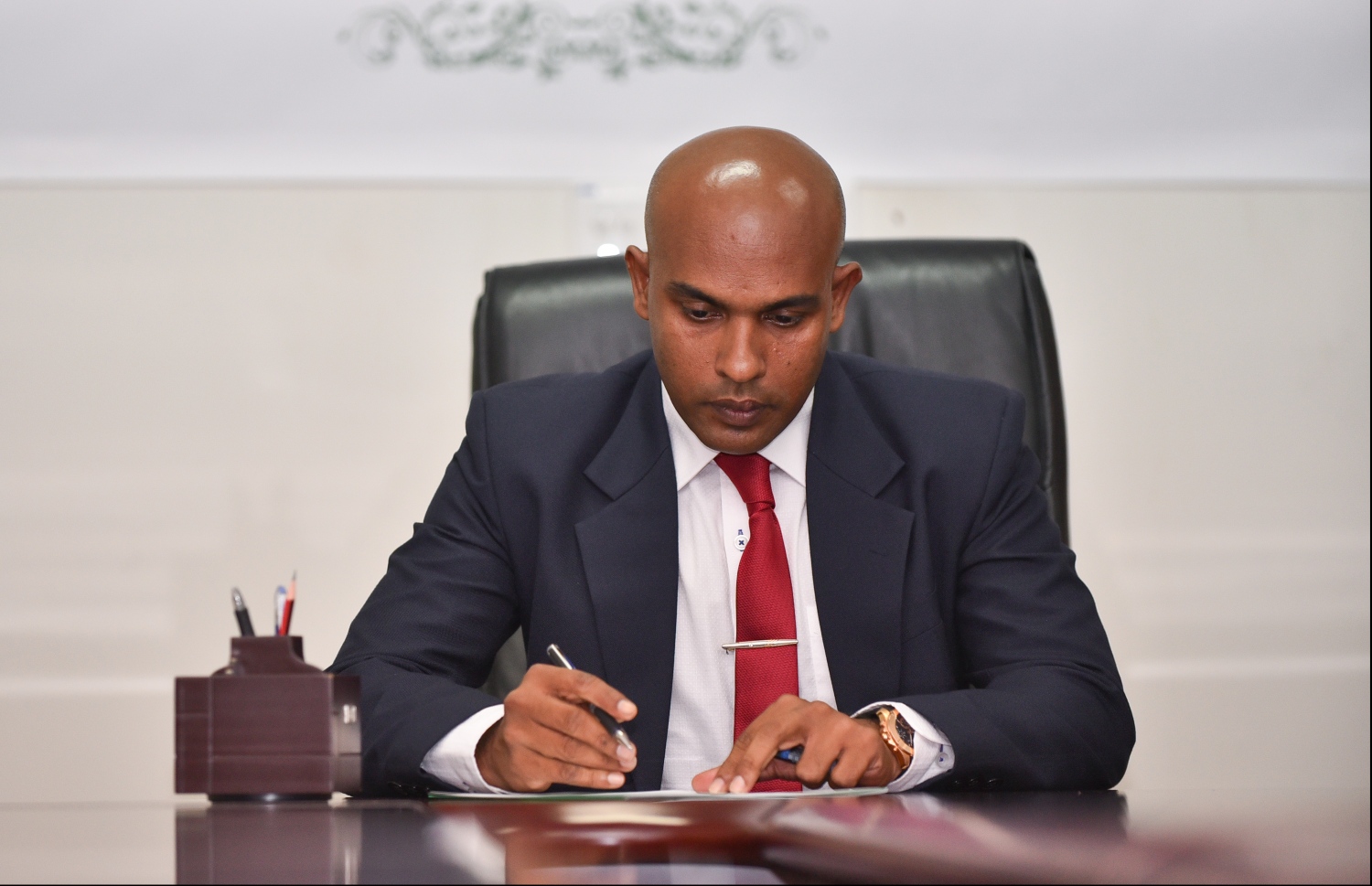 ފަނޑިޔާރު ކަމުގެ ހުވާ ކުރެއްވުމަށް ފަހު ހަސަން ލިޔުމުގައި ސޮއި ކުރައްވަނީ -- ފޮޓޯ: ހުސެއިން ވަހީދު/ މިހާރު