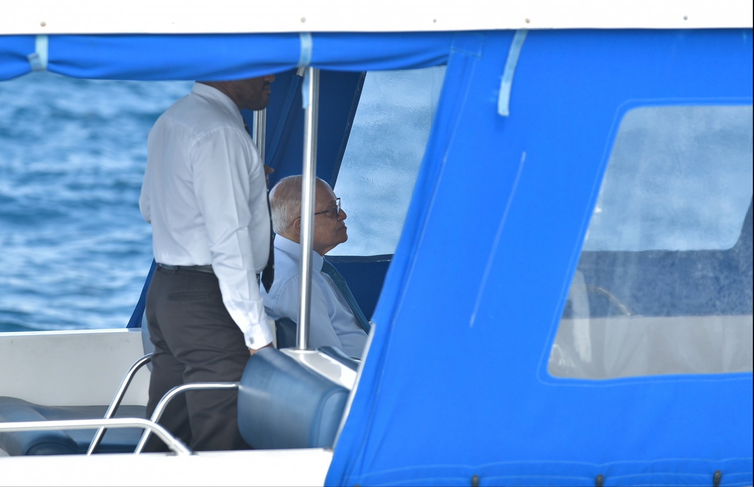 މާލެ: މާޗް 20، 2018- ސަރުކާރު ވައްޓާލަން އުޅުމުގެ ތުހުމަތަށް ހައްޔަރުކޮށްފައިވާ ކުރީގެ ރައީސް މައުމޫން އަބްދުލް ގައްޔޫމް ކޯޓަށް ހާޒިރުކުރަން ލޯންޗުގައި ގެންނަނީ.---ފޮޓޯ: ނިޝާން އަލީ/މިހާރު