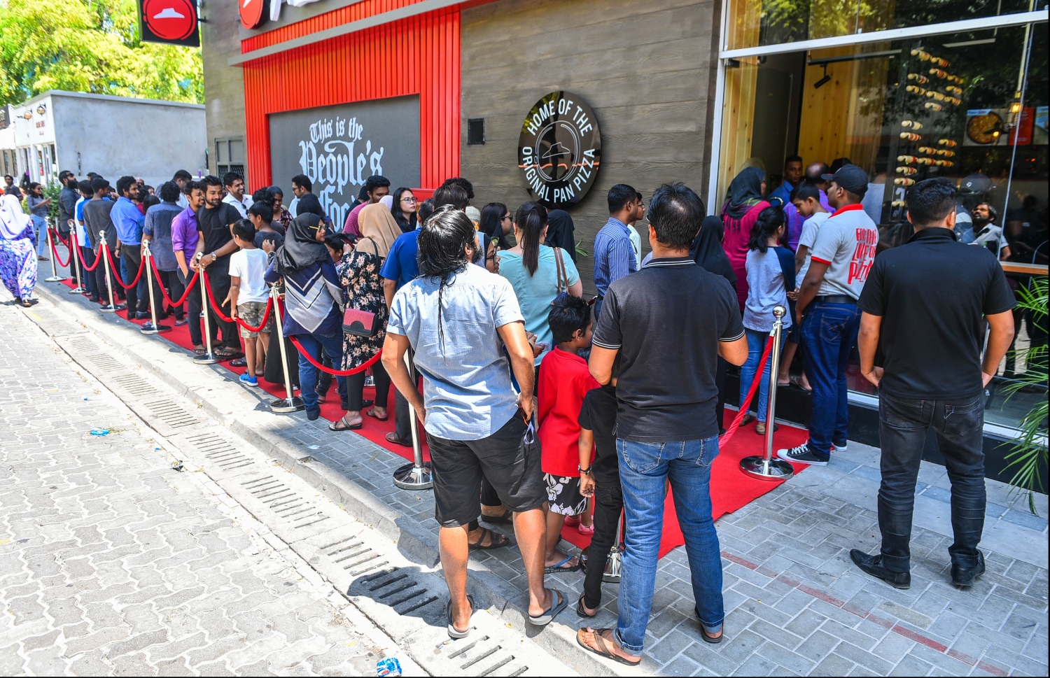 ޕިއްޒާ ހަޓްގެ ރެސްޓޯރަންޓެއް ފުރަތަމަ ފަހަރަށް ރާއްޖޭގައި ހުޅުވުމުން އެތަނުގެ ބޭރުގައި މިއަދު ހެނދުނު އެތައް ސަތޭކަ ބަޔަކު ކިޔޫ ހަދައިގެން: އެތަނަށް އާންމުންގެ އާދަޔާ ހިލާފު ބޮޑު ތަރުހީބެއް އަންނަނީ ލިބެމުން--. ފޮޓޯ:ހުސައިން ވަހީދު/މިހާރު