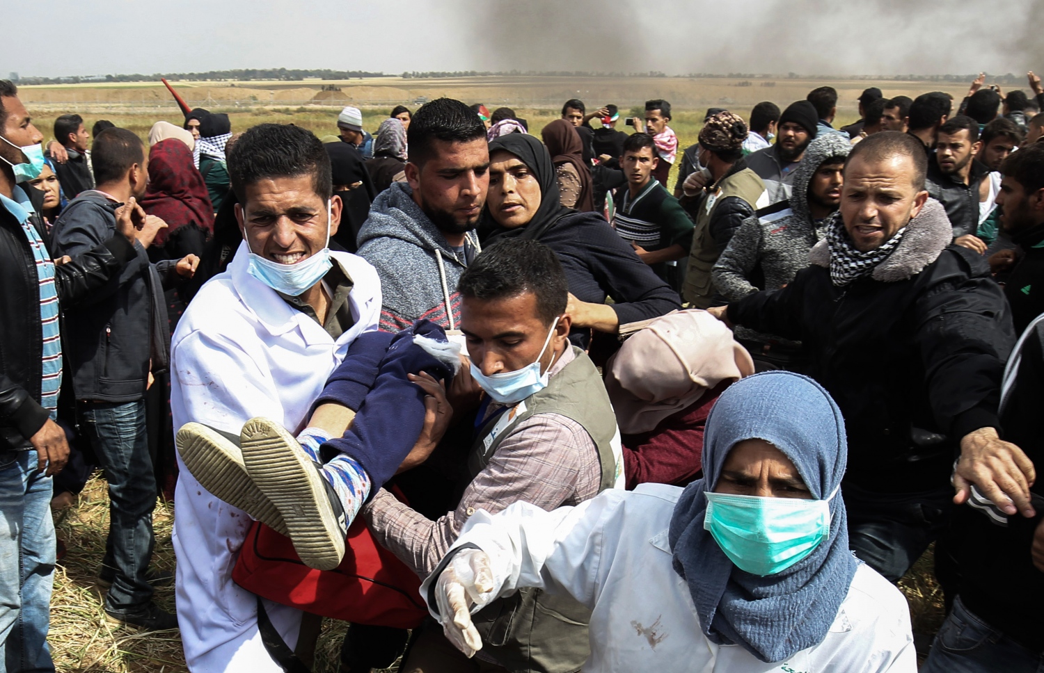 ގާޒާ ބޯޑަރުގެ އިހްތިޖާޖުގައި ޒަޚަމްވި ފަލަސްތީނުގެ އަންހެނަކު ގެންދަނީ. --ފޮޓޯ:އޭއެފްޕީ