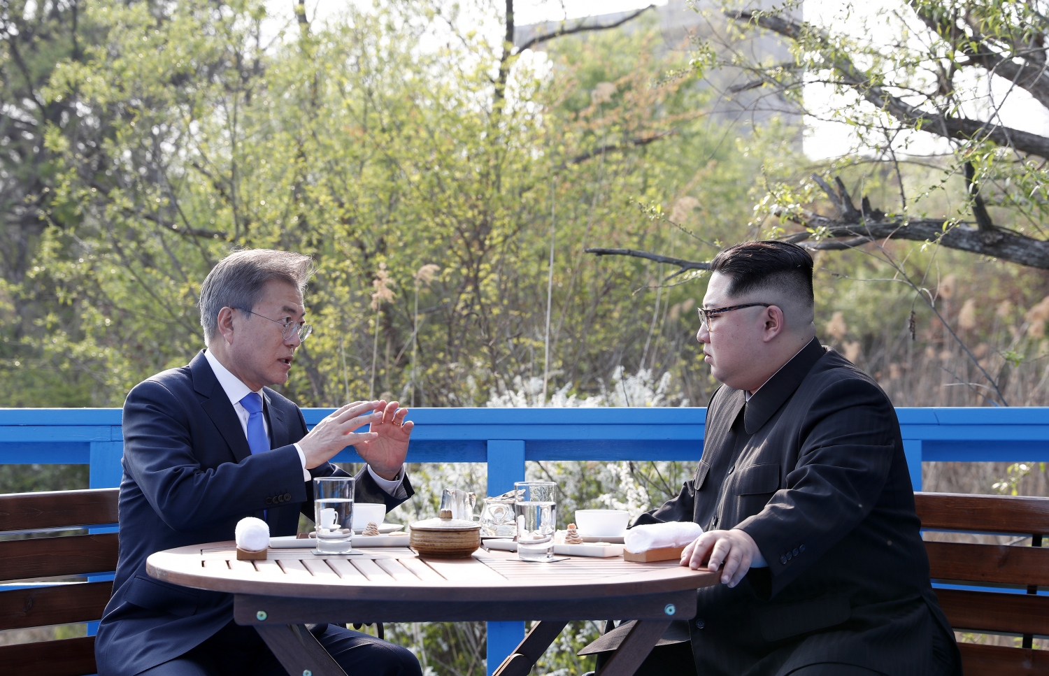 ނޯތު ކޮރެއާގެ ލީޑަރު ކިމް ޖޮން-އުން (ކ) އާއި ސައުތު ކޮރެއާގެ ރައީސް މޫން ޖައި-އިން ދެ ކޮރެއާ ގުޅޭ ސަރަހައްދުގެ ބްރިޖެއްގެ މަތީގައި ބެންޗެއްގައި ތިއްބަވާ މަޝްވަރާ ކުރައްވަނީ. --ފޮޓޯ:އޭއެފްޕީ